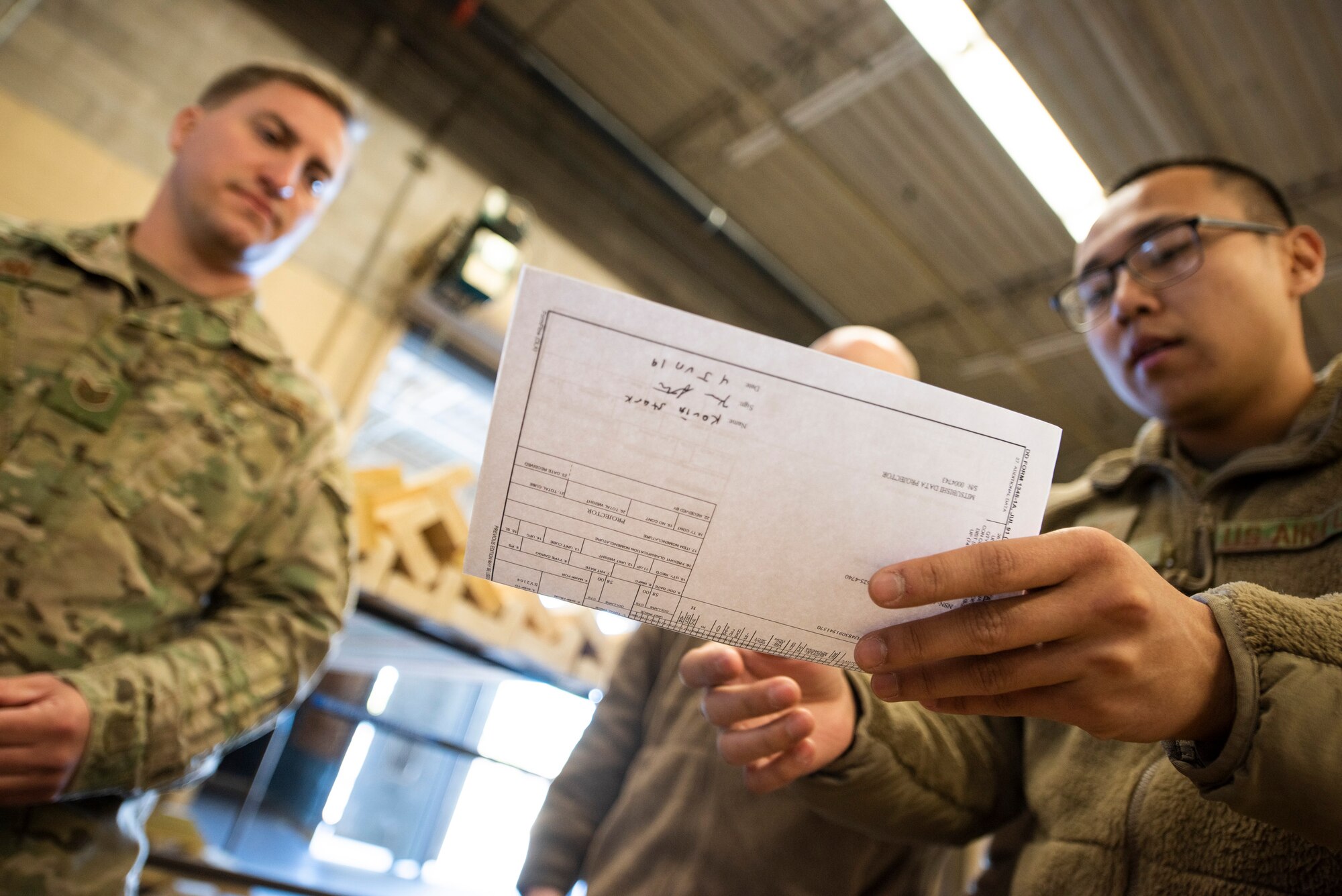 A photo of an Airman reviewing paperwork with another Airman.