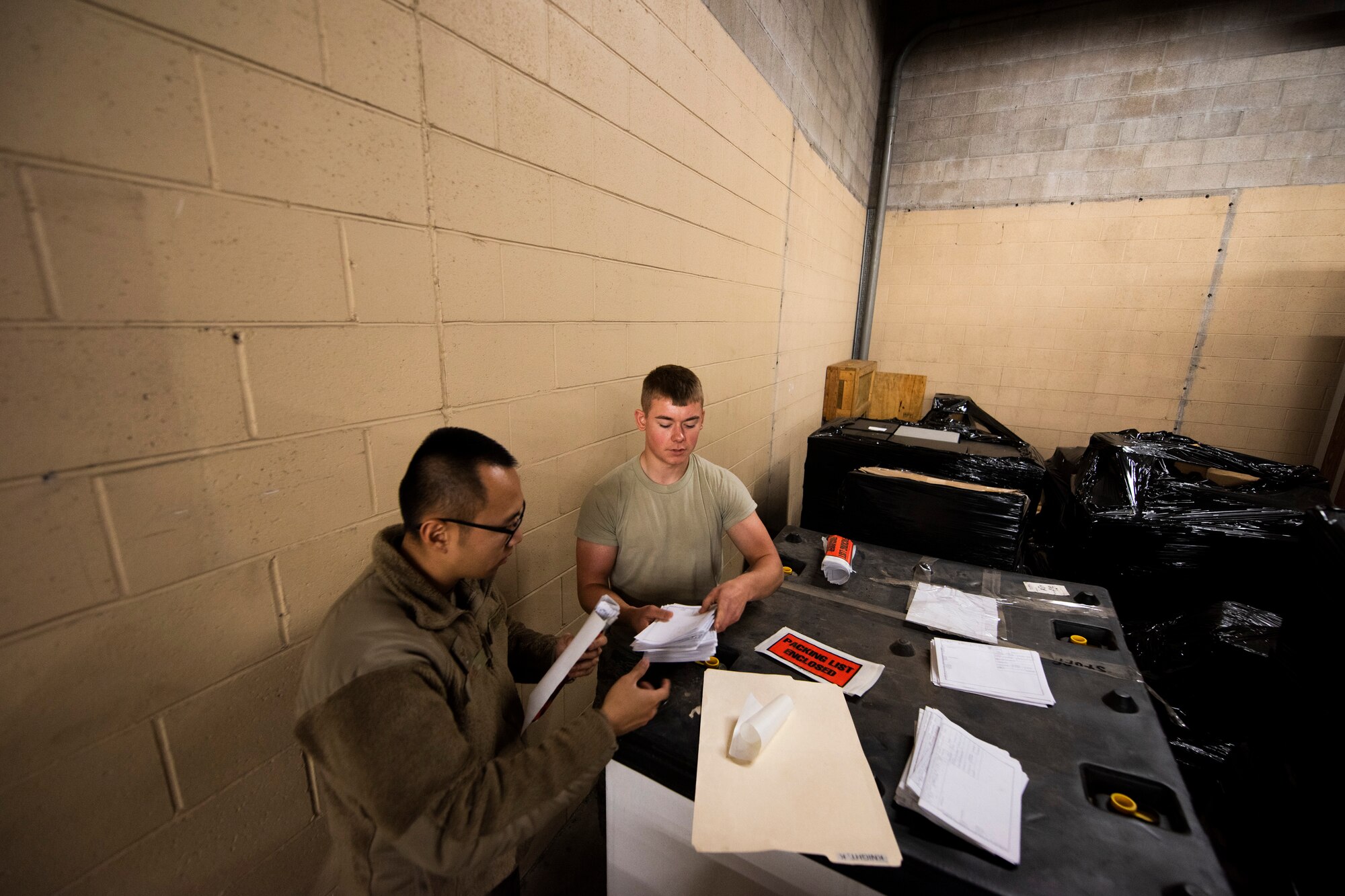 A photo of Airmen organizing shipment labels for old equipment.