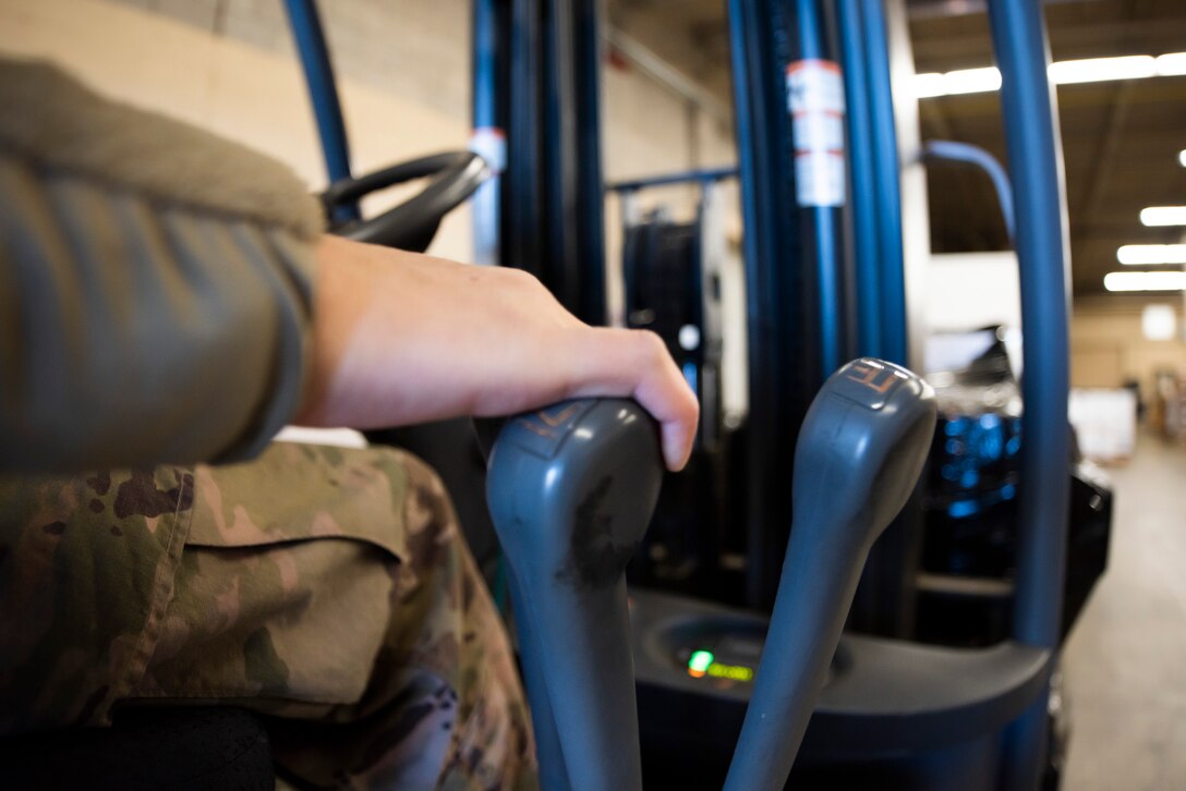 A photo of an Airman using a forklift to move a shipment.