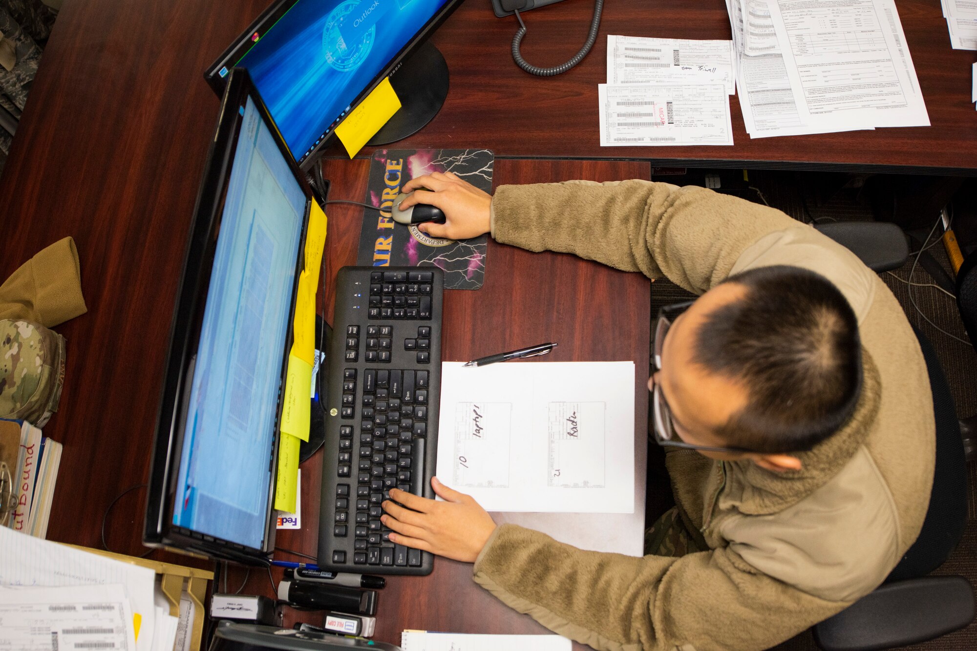 A photo of an Airman using a computer to fill out paperwork.