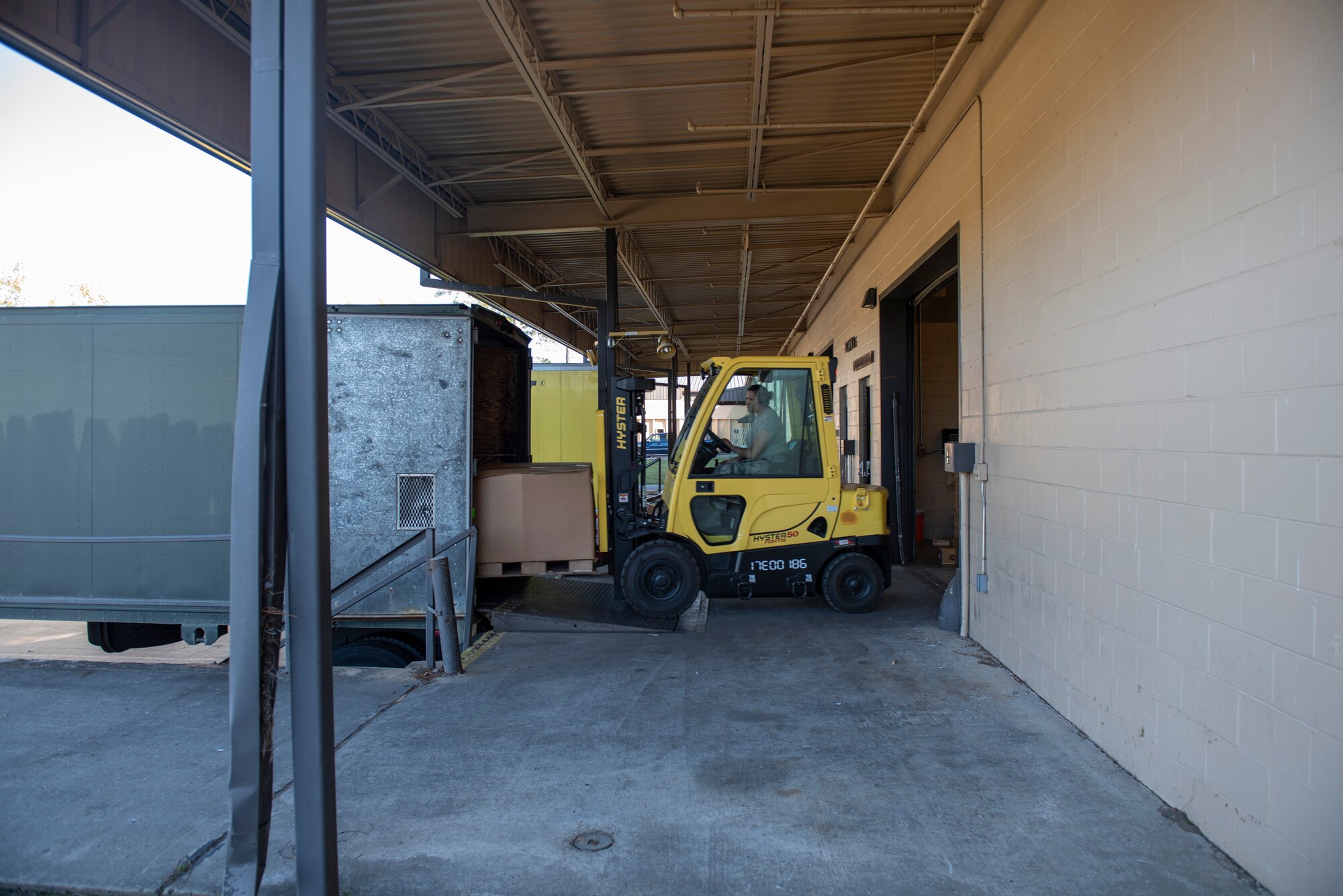 A photo of an Airman using a forklift to move a shipment into a truck.