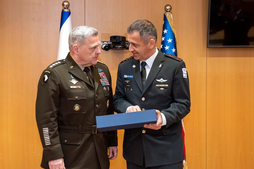 Two military leaders greet each other.