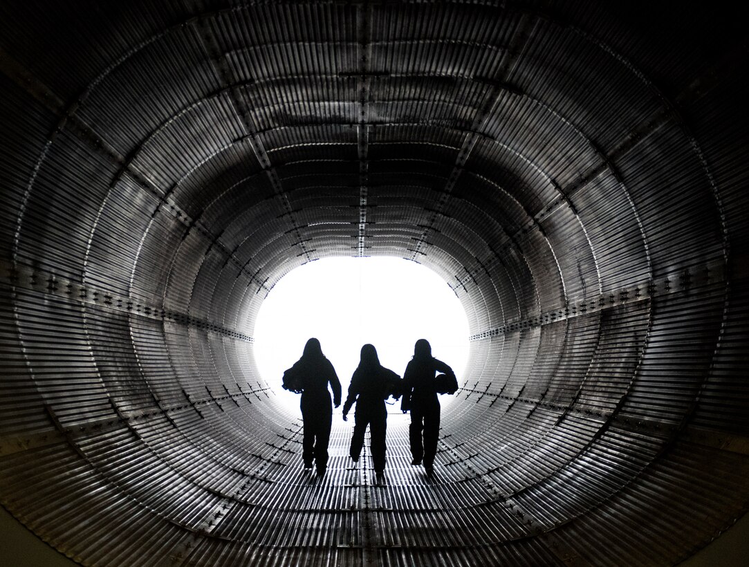 Duke University Hacking for Defense (H4D) students Joy Duer, Mary Gooneratne and Linda Zhang, walk through an engine inspection bay inside of the hush house during a tour, Nov. 15, 2019, Seymour Johnson Air Force Base, N.C. During the culmination period of their semester project, Joy Duer received an F-15E Strike Eagle flight. The H4D class assignment consisted of Duke University seniors finding a solution to a real-world command and control problem. (U.S. Air Force photo by Tech. Sgt. Vernon Young Jr.)