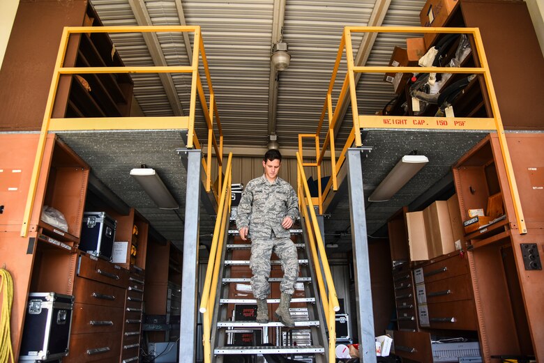 a photo of an Airman walking down the stairs.