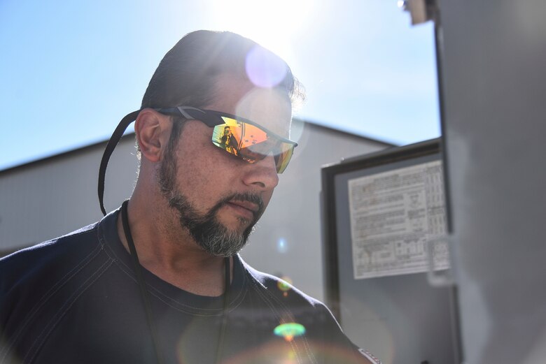 a photo of a utility maintenance repairman looking at a control panel