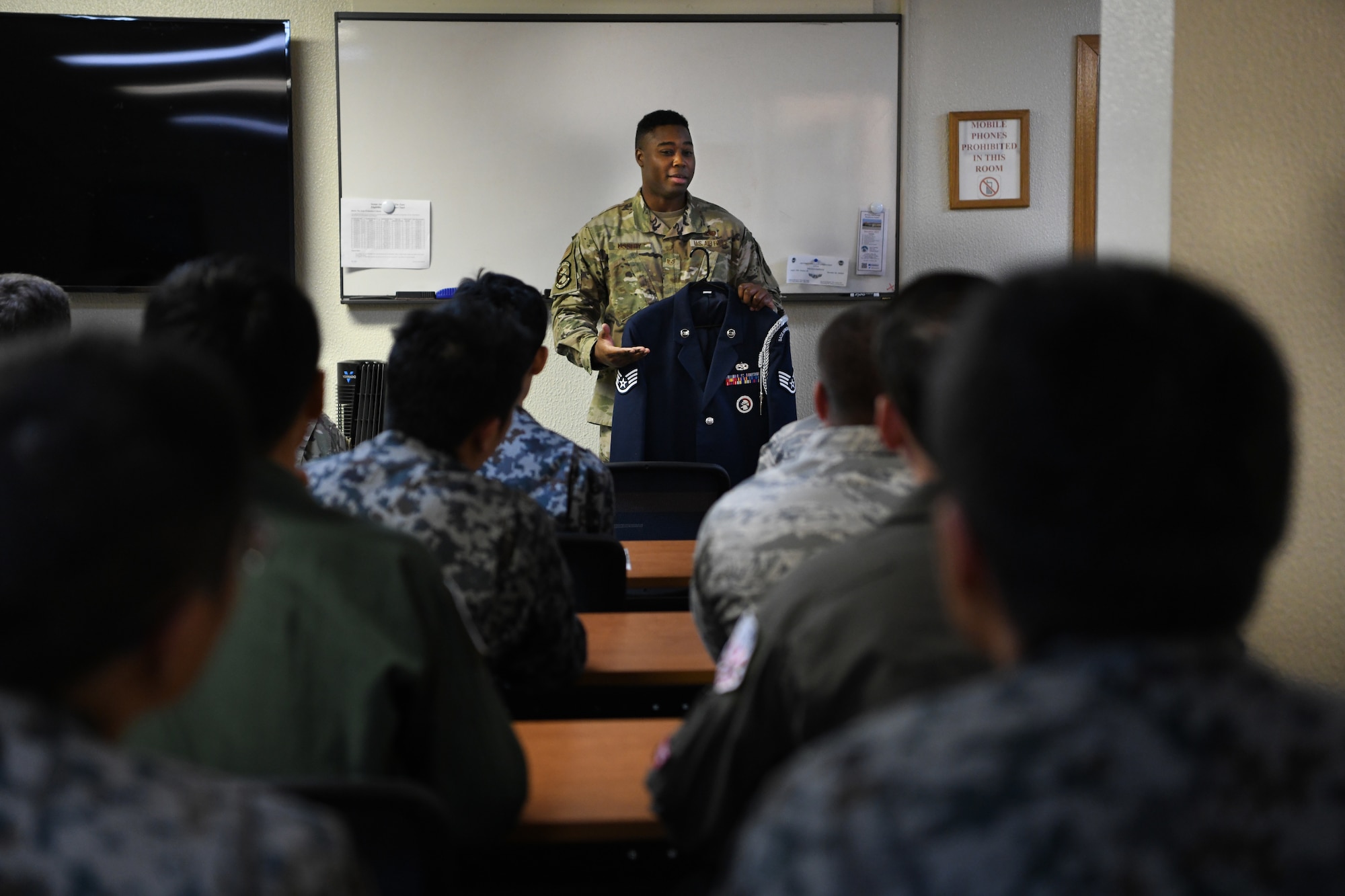 U.S. Air Force Staff Sgt. Calvin Ussery, 18th Force Support Squadron ceremonial guardsman, center, points out the differences in a ceremonial guardsman’s service dress and a regular Airman’s for U.S. Air Force,U.S. Army, and Japanese Self-Defense Force members participating in an NCO Bilateral Exchange program Nov. 15, 2019, at Kadena Air Base, Japan. Bilateral exchanges allow for a better understanding of the capabilities held by each countries Armed Forces, as well as the opportunity to improve relations between the United States and Japan. (U.S. Air Force photo by Senior Airman Rhett Isbell)
