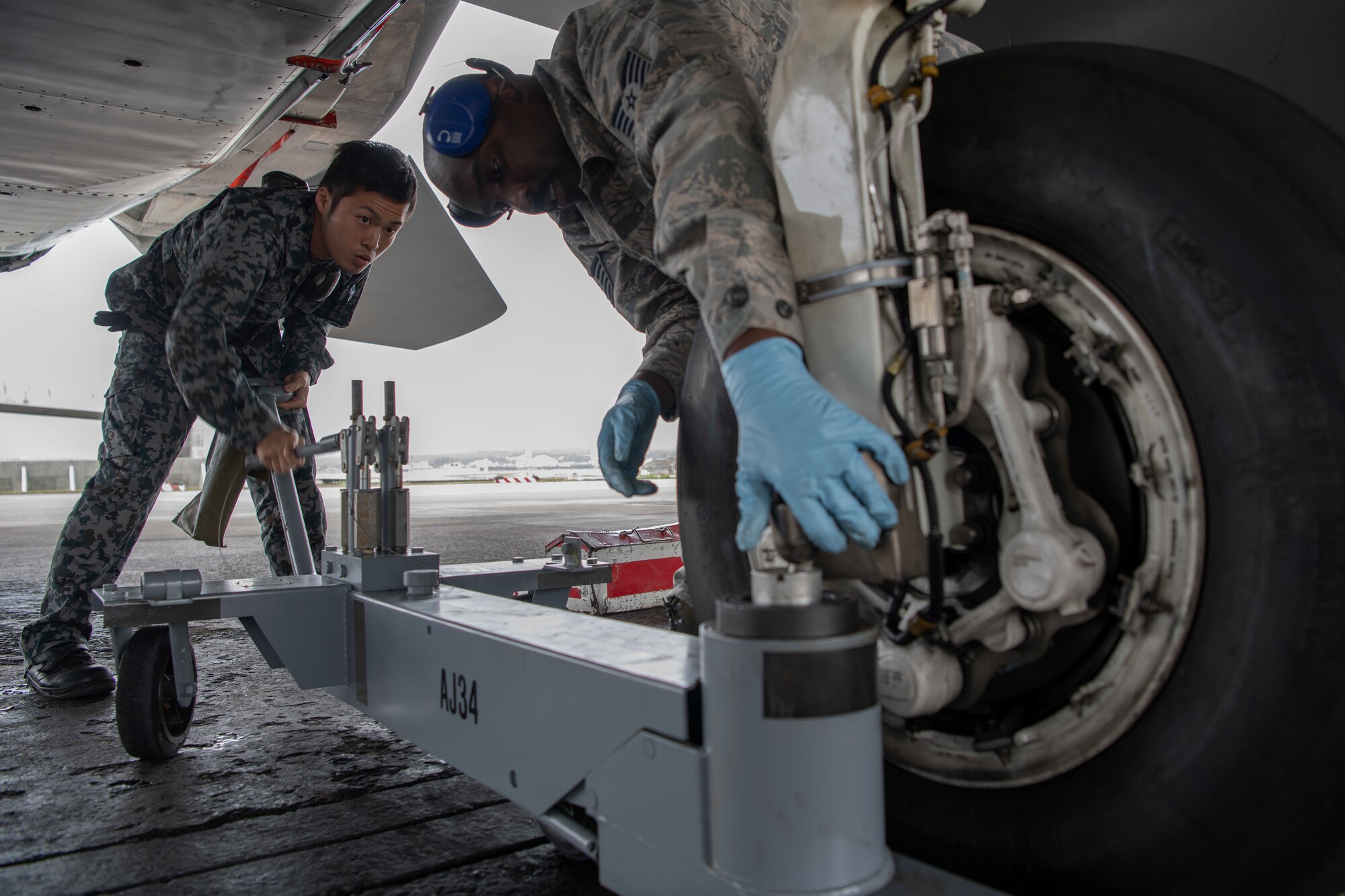 Japanese Self-Defense Force Staff Sgt. Shuichiro Masunaga, 6th Tactical Fighter Squadron aircraft general technician, left, and U.S. Air ForceTech. Sgt. Adrian Lemard, 18th Aircraft Maintenance Squadron crew chief, train on changing tires on an F-15C Eagle as part of an NCO Bilateral Exchange program Nov. 19, 2019, at Kadena Air Base, Japan. Bilateral exchanges allow for a better understanding of the capabilities held by each countries Armed Forces,as well as the opportunity to improve relations between the United States and Japan. (U.S. Air Force photo by Senior Airman Rhett Isbell)