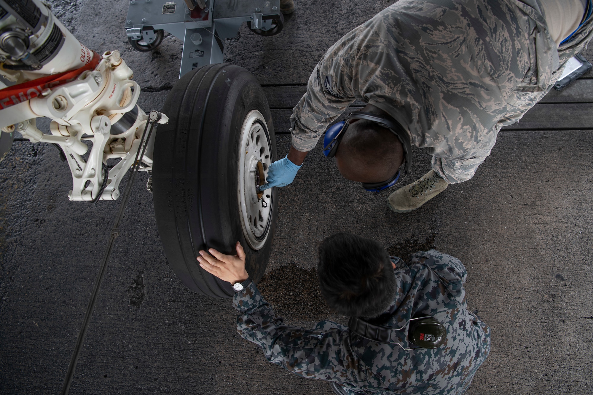 Japanese Self-Defense Force Staff Sgt. Shuichiro Masunaga, 6th Tactical Fighter Squadron aircraft general technician, left, and U.S. Air ForceTech. Sgt. Adrian Lemard, 18th Aircraft Maintenance Squadron crew chief, train on changing tires on an F-15C Eagle as part of an NCO Bilateral Exchange program Nov. 19, 2019, at Kadena Air Base, Japan. Bilateral exchanges allow for a better understanding of the capabilities held by each countries Armed Forces,as well as the opportunity to improve relations between the United States and Japan. (U.S. Air Force photo by Senior Airman Rhett Isbell)