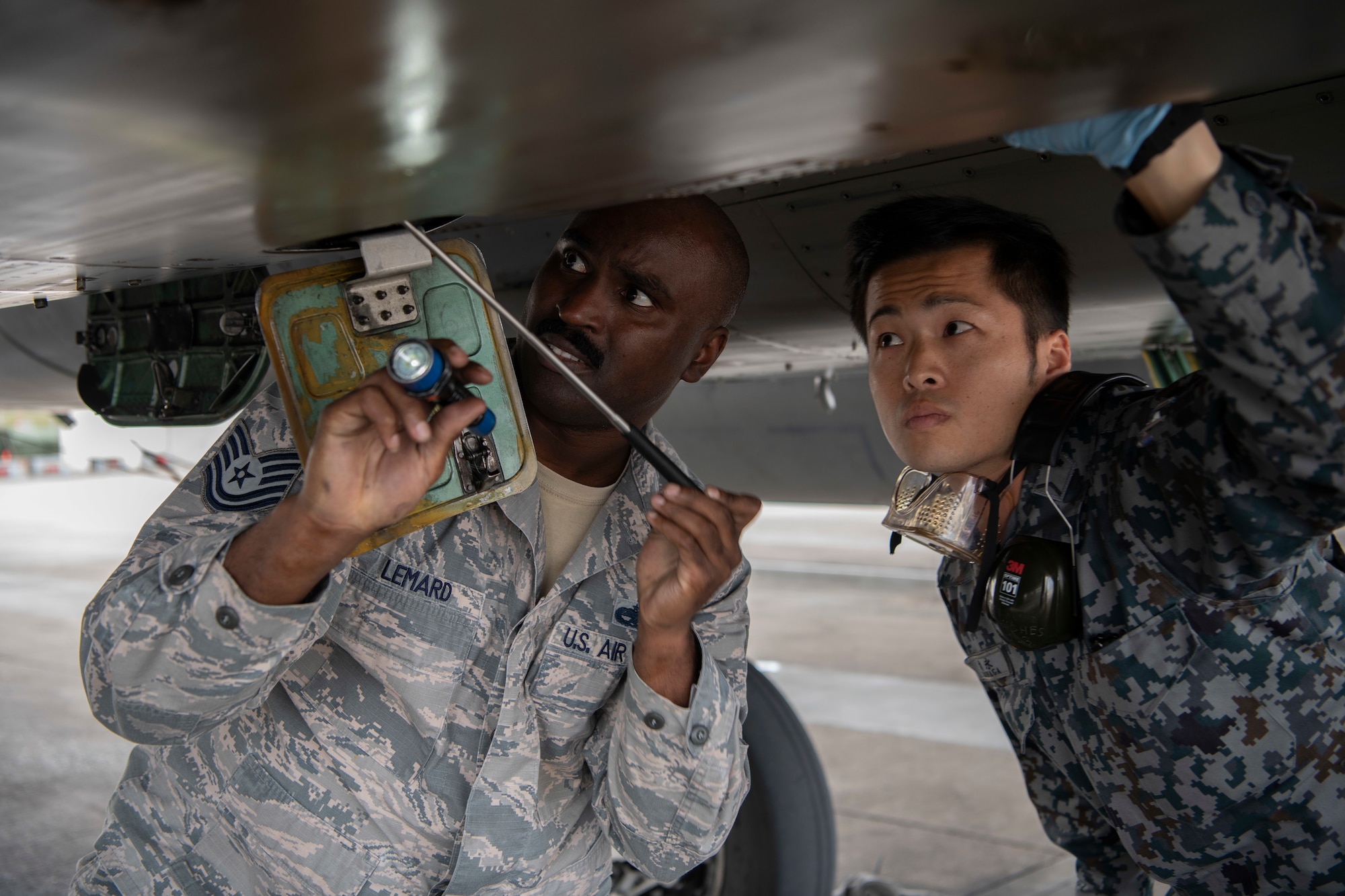 U.S. Air Force Tech. Sgt. Adrian Lemard, 18th Aircraft Maintenance Squadron crew chief, left, and  Japanese Self-Defense Force Staff Sgt. Shuichiro Masunaga, 6th Tactical Fighter Squadron aircraft general technician, right, perform thru-flight checks on an F-15C Eagle as part of an NCO Bilateral Exchange program Nov. 19, 2019, at Kadena Air Base, Japan. Bilateral exchanges allow for a better understanding of the capabilities held by each countries Armed Forces, as well as the opportunity to improve relations between the United States and Japan. (U.S. Air Force photo by Senior Airman Rhett Isbell)