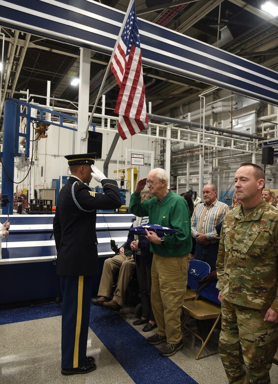 An image of Dwight Journey receiving a salute by the Army Honor Guard, following a flag presentation to honor his brother, TSgt. Bruce Journey