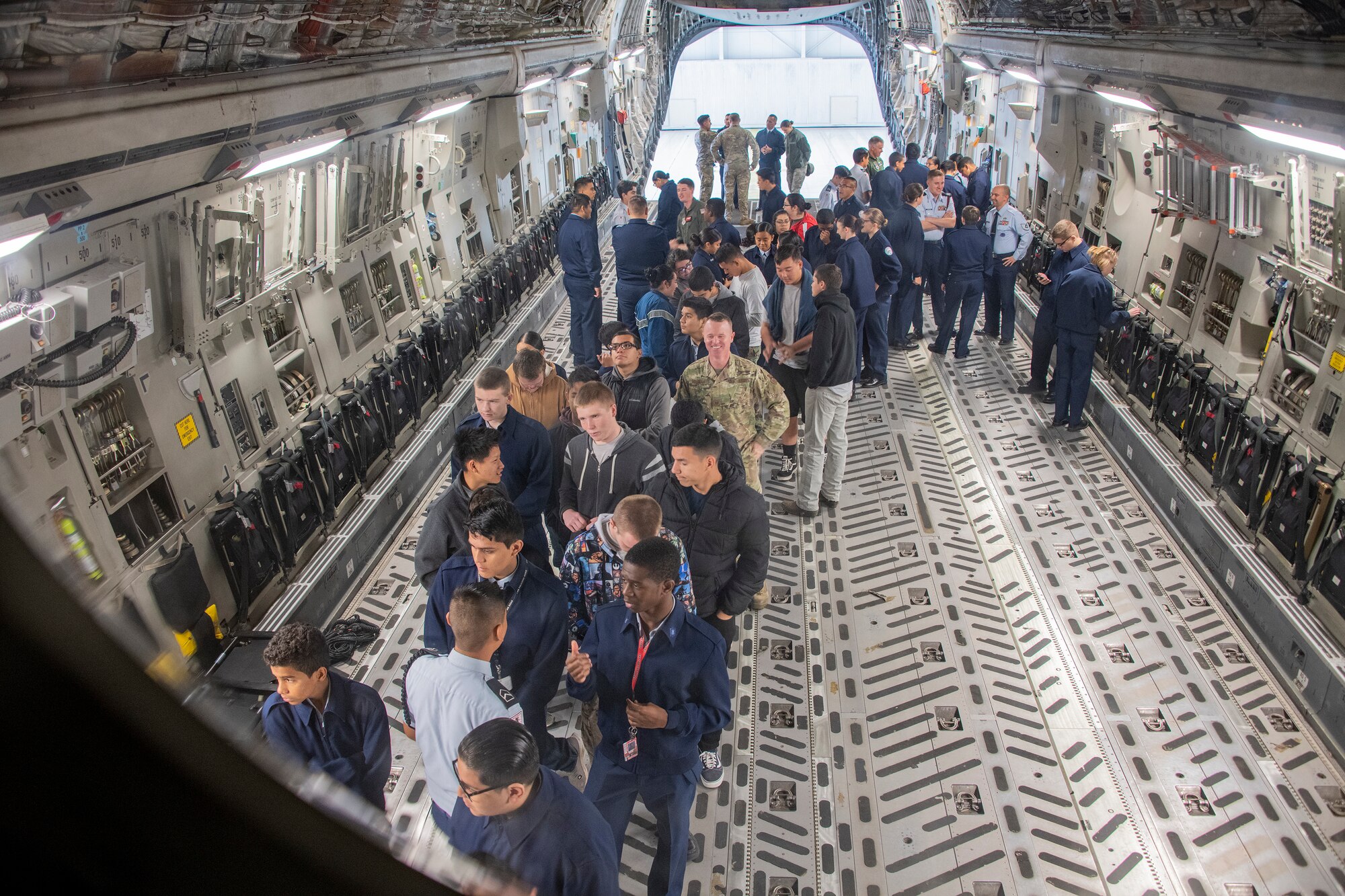 Students wait in line to see the flight deck of a C-17 Globemaster III Nov. 21, 2019, at Travis Air Force Base, California. Travis AFB hosted Junior Reserve Officer Training Corps students from five Northern California high schools and one Oregon high school. The students learned about various U.S. Air Force career fields and toured static aircraft, the Heritage Center museum and dormitories. They also talked with Airmen about military life. (U.S. Air Force photo by Heide Couch)