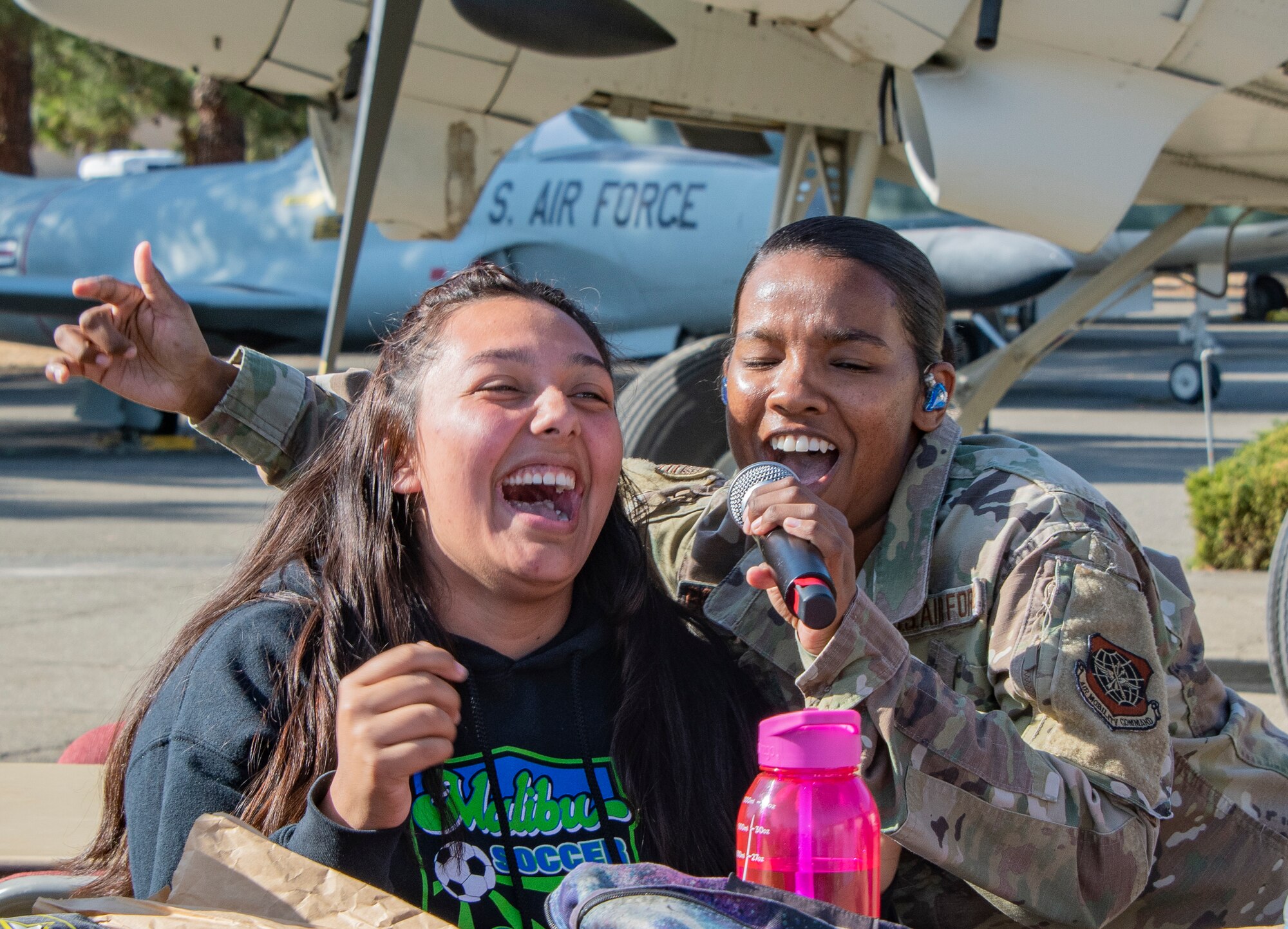 U.S. Air Force Senior Airman Salina Boodoosingh, a vocalist with the United States Air Force Band of the Golden West, motivates student participation during a performance Nov. 21, 2019, Travis Air Force Base, California. Travis AFB hosted Junior Reserve Officer Training Corps students from five Northern California high schools and one Oregon high school. The students learned about various U.S. Air Force career fields and toured static aircraft, the Heritage Center museum and dormitories. They also talked with Airmen about military life. (U.S. Air Force photo by Heide Couch)