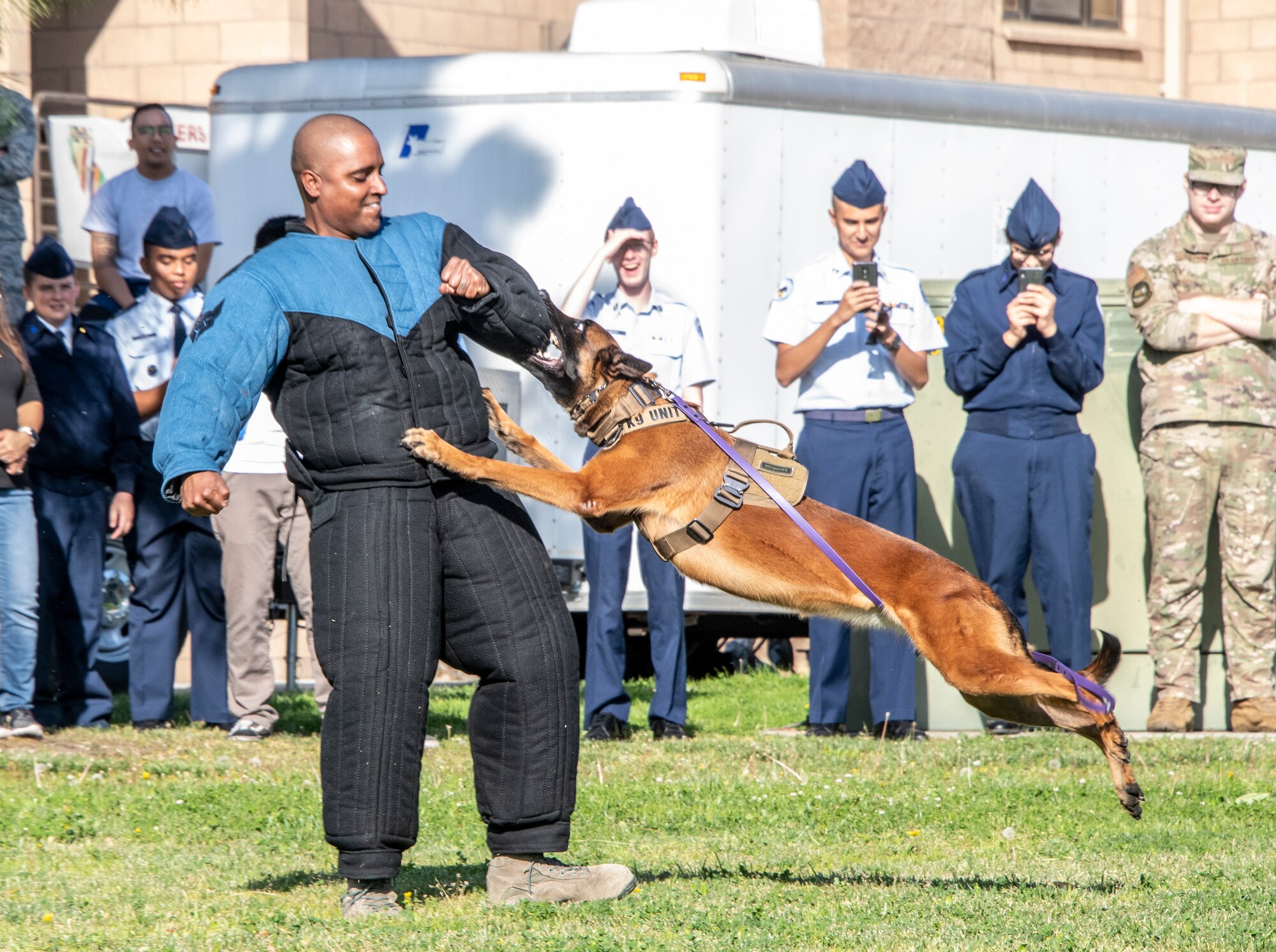 U.S. Air Force Staff Sgt. Jerry Jasmin, 60th Security Forces Squadron military working dog handler, works with Aarapaho during a demonstration Nov. 21, 2019, Travis Air Force Base, California. Travis AFB hosted Junior Reserve Officer Training Corps students from five Northern California high schools and one Oregon high school. The students learned about various U.S. Air Force career fields and toured static aircraft, the Heritage Center museum and dormitories. They also talked with Airmen about military life. (U.S. Air Force photo by Heide Couch)