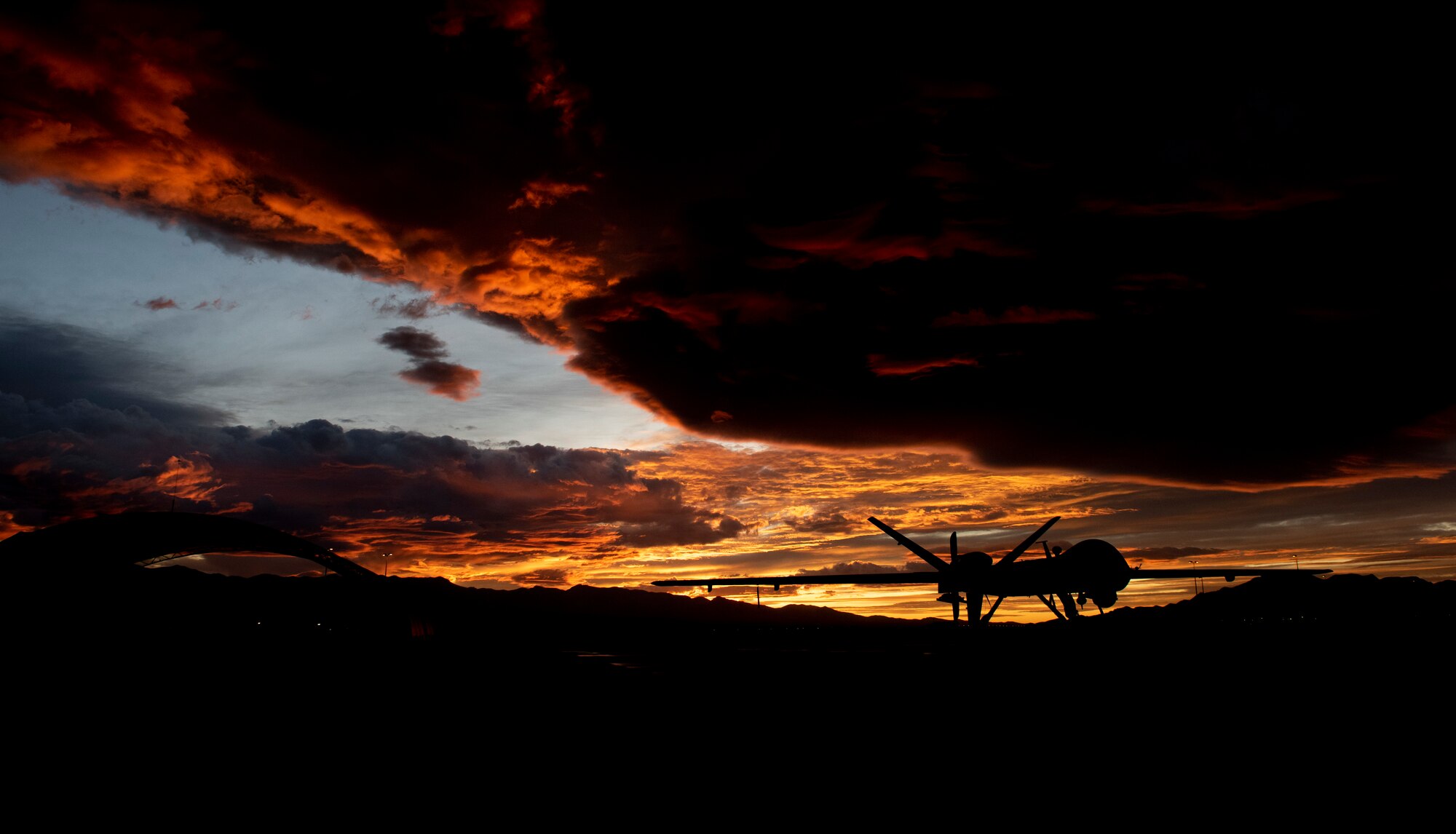 An MQ-9 Reaper sits on the flight line underneath a Nevada sunset.