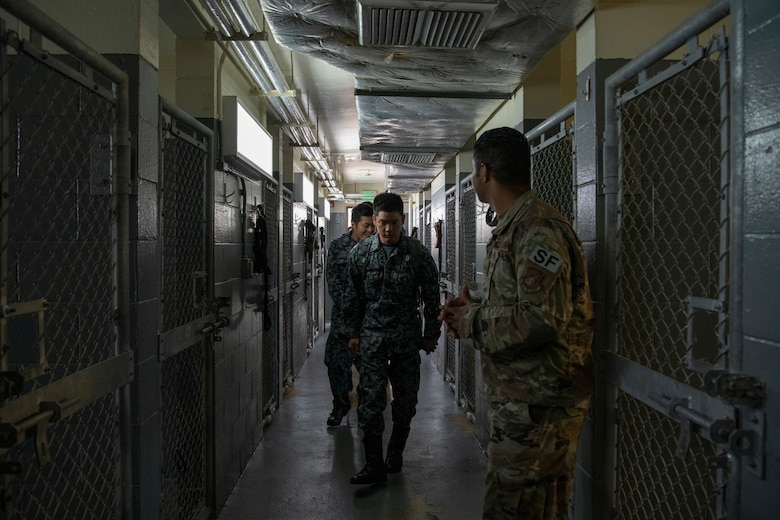 U.S. Air Force Tech. Sgt. Mario Rey, 18th Security Forces Squadron military working dog handler, right, guides U.S. Air Force, U.S. Army, and Japanese Self-Defense Force members participating in an NCO Bilateral Exchange program through the 18th SFS kennels Nov. 18, 2019, at Kadena Air Base, Japan. Bilateral exchanges allow for a better understanding of the capabilities held by each countries Armed Forces, as well as the opportunity to improve relations between the United States and Japan. (U.S. Air Force photo by Senior Airman Rhett Isbell)