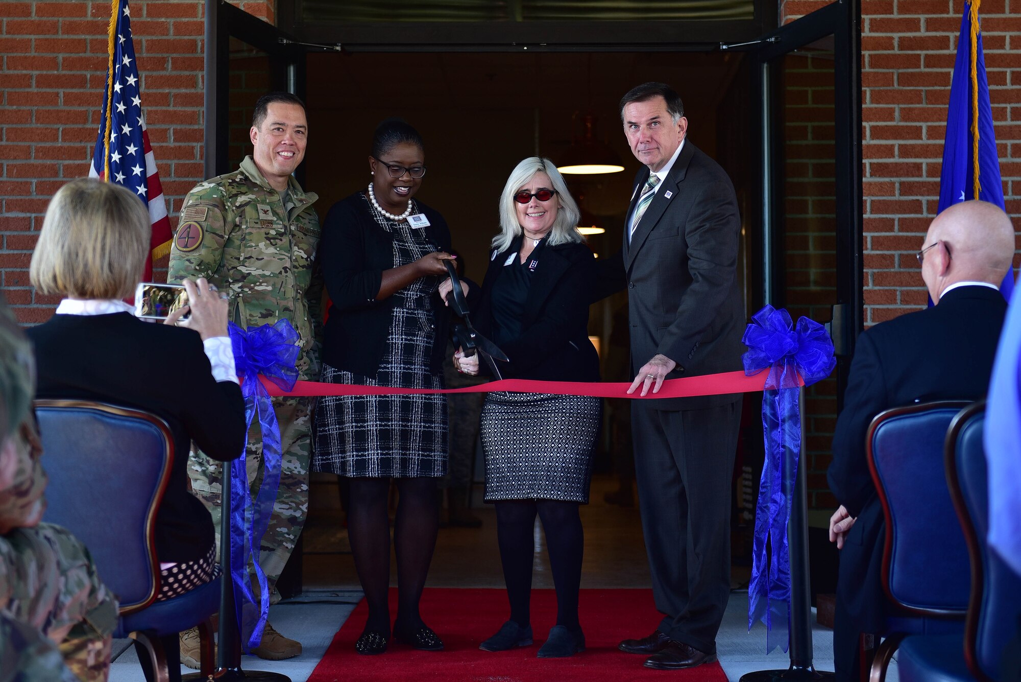 Col. Donn Yates, 4th Fighter Wing commander, left, along with members of the USO of North Carolina cut the ribbon during a ceremony marking the opening of a new USO of North Carolina center, Nov. 21, 2019, at Seymour Johnson Air Force Base, N.C. The new USO of NC – SJAFB Center will serve the more than 6,000 Airmen stationed on base, along with any other DOD ID card holder. (U.S. Air Force photo by Senior Airman Victoria Boyton)
