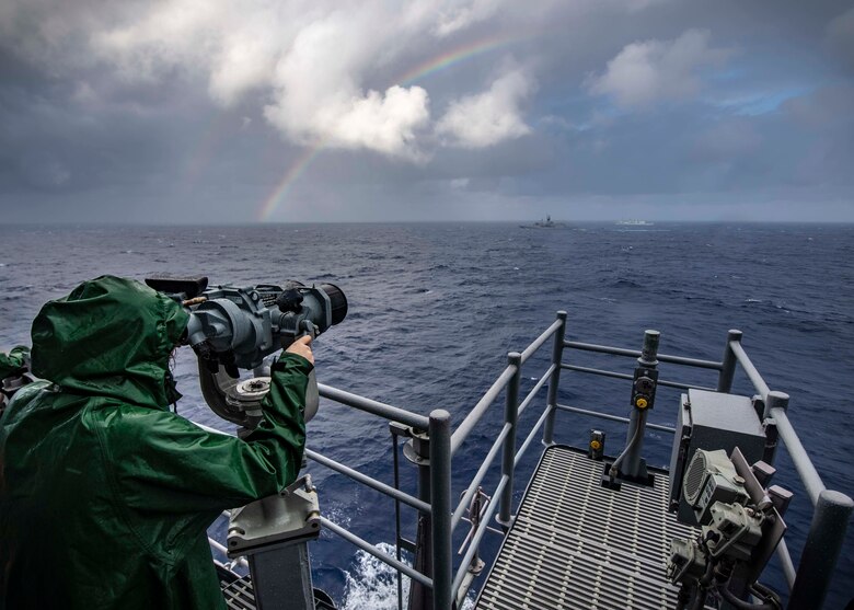 PHILIPPINE SEA (Nov. 21, 2019) Lt. j.g. Katherine Lindman, from Minneapolis, looks through binoculars on the bridge of the Ticonderoga-class guided-missile cruiser USS Chancellorsville (CG 62) during a group maneuvering exercise with ships from the Royal Australian Navy, Royal Canadian Navy, and Republic of Korea Navy as part of Pacific Vanguard 2019. Chancellorsville is forward-deployed to the U.S. 7th Fleet area of operations in support of security and stability in the Indo-Pacific region.