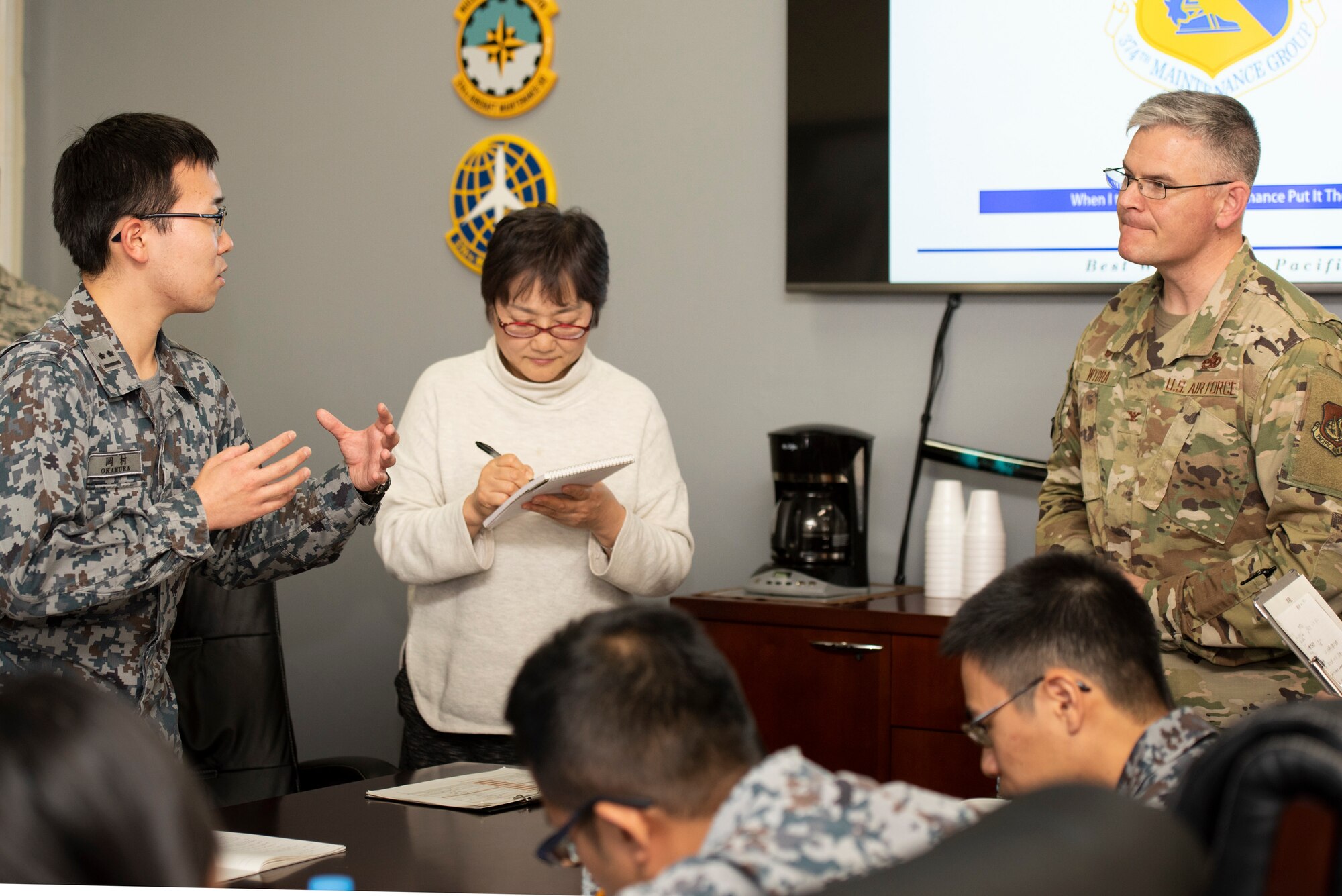 A Japanese Air Self-Defense Force Lieutenant, left, asks Col. Todd Wydra, 374th Maintenance Group Commander, right, a question after the initial briefing during a basic maintenance officer tour at Yokota Air Base, Japan, Nov. 21, 2019.
