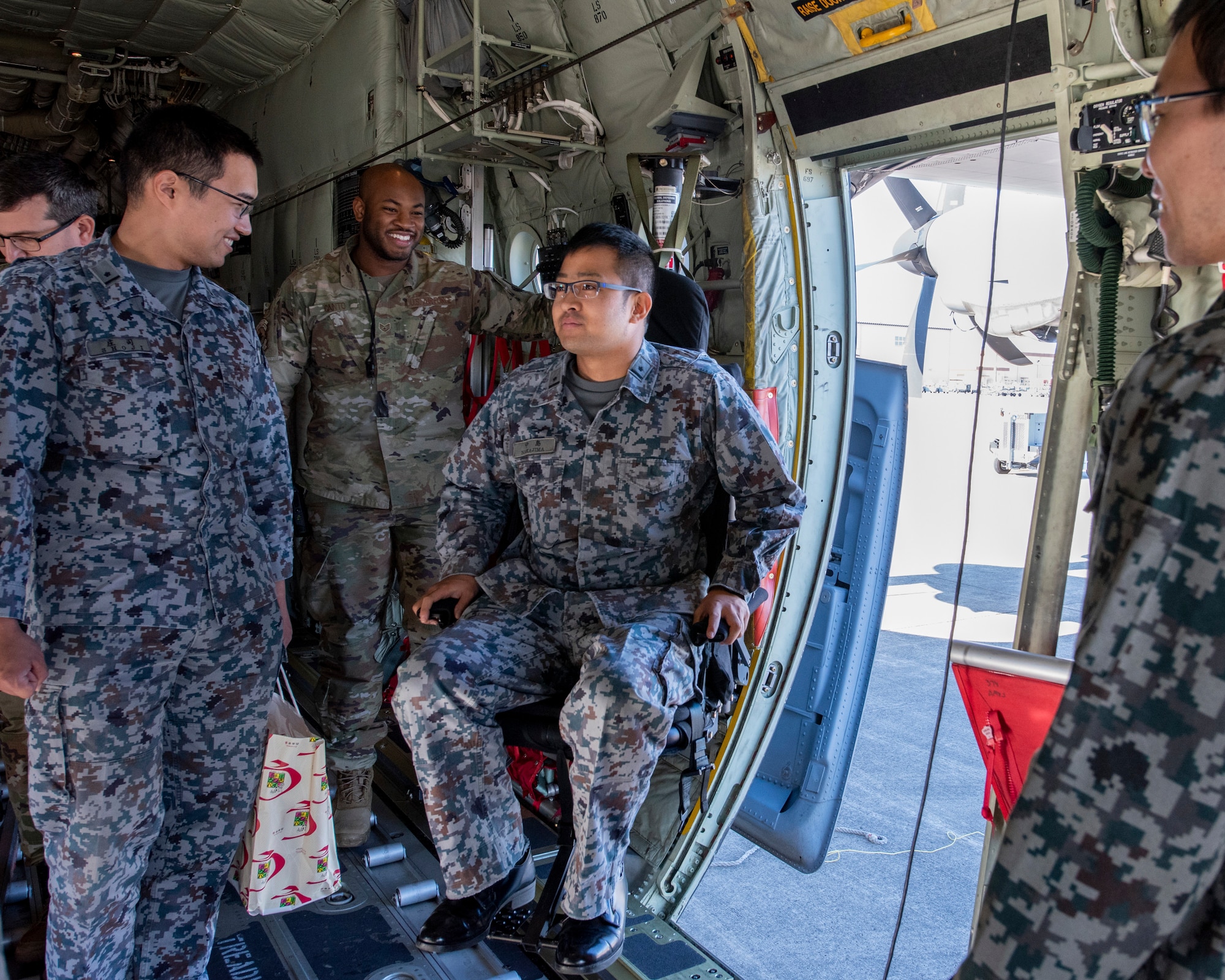 A Japanese Air Self-Defense Force Lieutenant sits in a loadmaster’s crash-worthy seat on a C-130J Super Hercules during a basic maintenance officer tour at Yokota Air Base, Japan, Nov. 21, 2019.