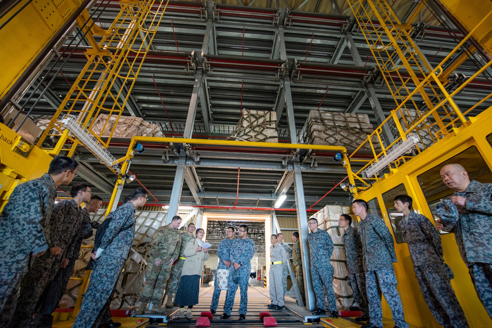 Tech.Sgt. Austin Kelley, 730th Air Mobility Squadron air freight shift supervisor, explains the capabilities of a Mechanized Material Handling System to Japanese Air Self-Defense Force Lieutenants during a basic maintenance officer tour at Yokota Air Base, Japan, Nov. 21, 2019.