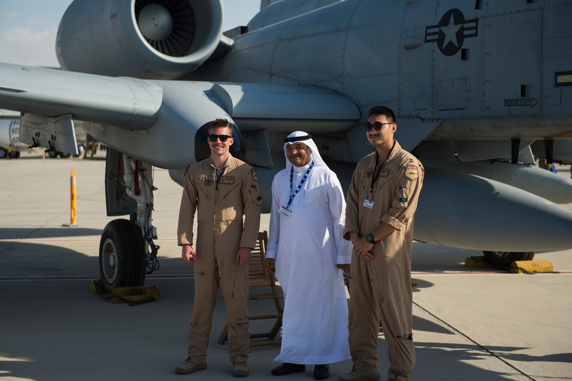 U.S. Air Force 1st Lt. Jacob Wulfson, left, and U.S. Air Force Capt. Alexander Boules, A-10 Thunderbolt II pilots, pose for a photograph alongside a spectator in front of an A-10 at the Dubai Airshow, United Arab Emirates, Nov. 17, 2019.