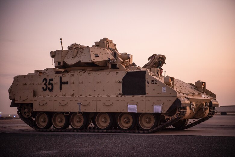 A U.S. Army M2 Bradley Fighting Vehicle is driven across the flight line toward a U.S. Air Force C-17 Globemaster III at Ali Al Salem Air Base, Kuwait, Oct. 30, 2019. Airmen and Soldiers coordinated efforts to transport the BFV within the U.S. Central Command theater of operations to assist in ongoing efforts within the region. (U.S. Air Force photo by Capt. Thomas Barger)
