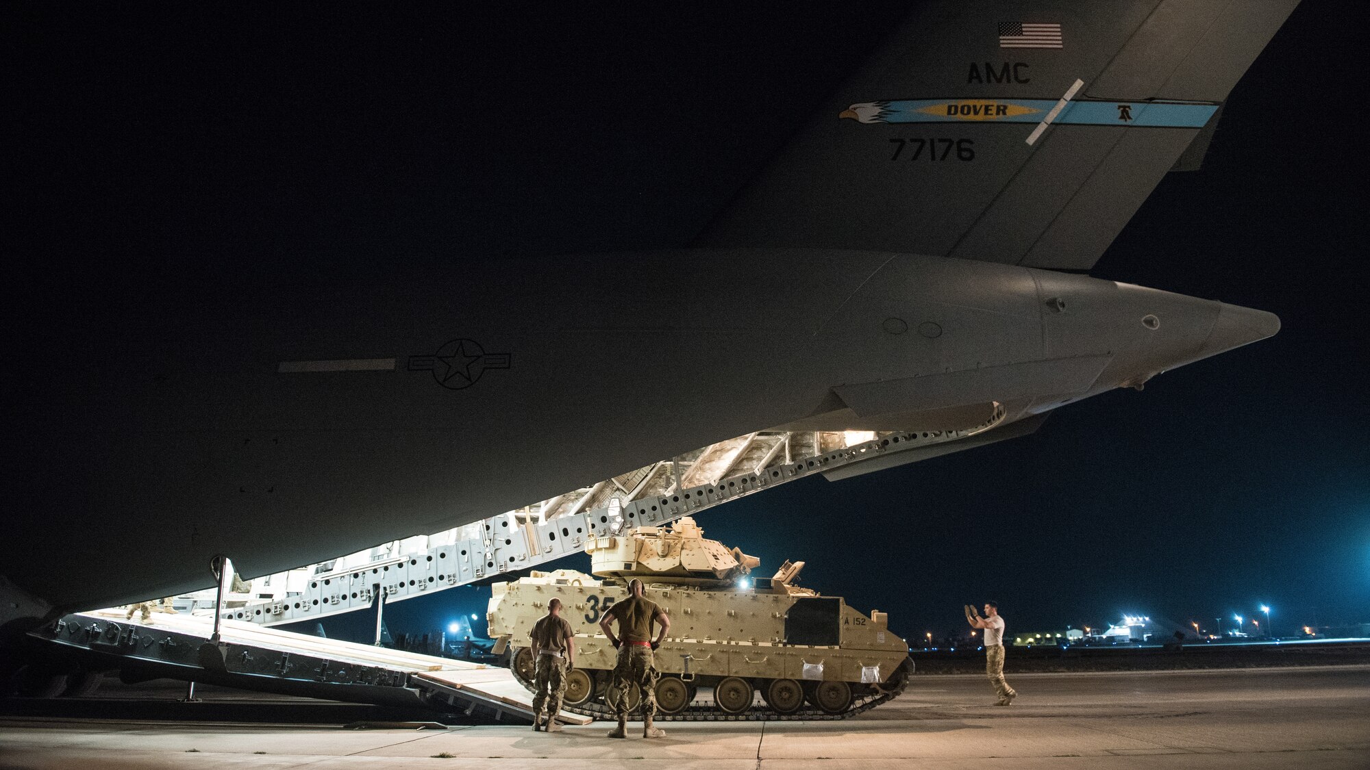 U.S. Airmen assigned to the 386th Expeditionary Logistics Readiness Squadron help guide a U.S. Army Soldier loading an M2 Bradley Fighting Vehicle onto a U.S. Air Force C-17 Globemaster III at Ali Al Salem Air Base, Kuwait, Oct. 30, 2019. Airmen and Soldiers coordinated efforts to transport the BFV within the U.S. Central Command theater of operations to assist in ongoing efforts within the region. (U.S. Air Force photo by Capt. Thomas Barger)