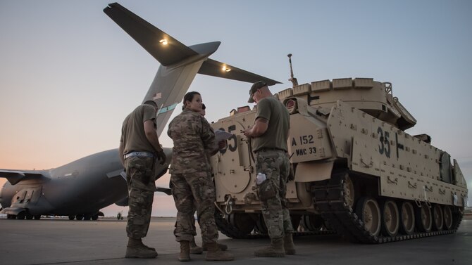 U.S. Airmen assigned to the 386th Expeditionary Logistics Readiness Squadron review paperwork before loading a U.S. Army M2 Bradley Fighting Vehicle onto a U.S. Air Force C-17 Globemaster III at Ali Al Salem Air Base, Kuwait, Oct. 30, 2019. Airmen and Soldiers coordinated efforts to transport the BFV within the U.S. Central Command theater of operations to assist in ongoing efforts within the region. (U.S. Air Force photo by Tech. Sgt. Daniel Martinez)