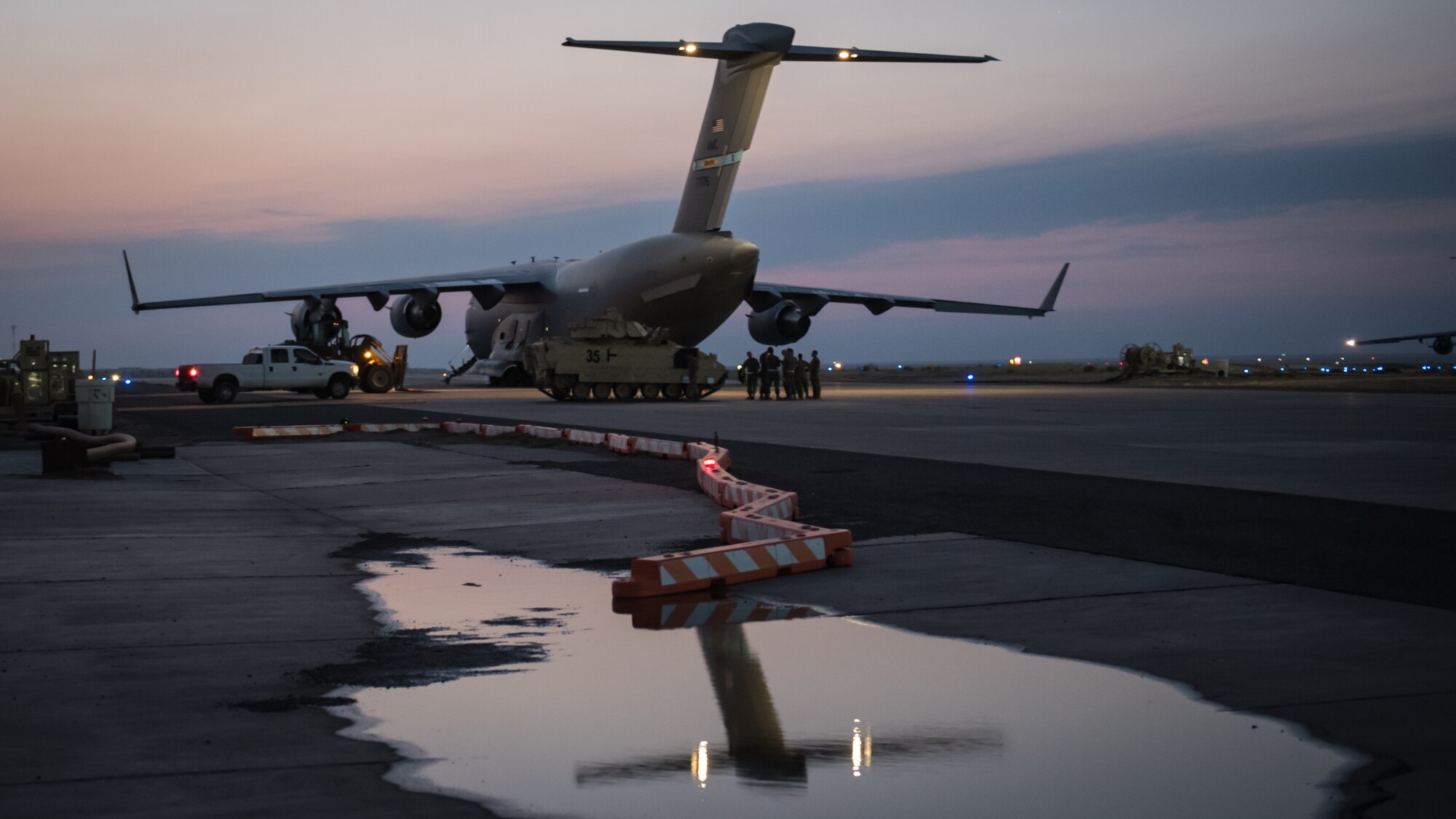 U.S. Airmen stand beside a U.S. Air Force C-17 Globemaster III in preparation to load a U.S. Army M2 Bradley Fighting Vehicle onto the aircraft at Ali Al Salem Air Base, Kuwait, Oct. 30, 2019. Airmen and Soldiers coordinated efforts to transport the BFV within the U.S. Central Command theater of operations to assist in ongoing efforts within the region. (U.S. Air Force photo by Tech. Sgt. Daniel Martinez)