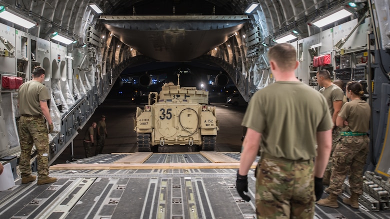 U.S. Airmen assigned to the 386th Expeditionary Logistics Readiness Squadron help guide a U.S. Army Soldier loading a U.S. Army M2 Bradley Fighting Vehicle onto a U.S. Air Force C-17 Globemaster III at Ali Al Salem Air Base, Kuwait, Oct. 30, 2019. Airmen and Soldiers coordinated efforts to transport the BFV within the U.S. Central Command theater of operations to assist in ongoing efforts within the region. (U.S. Air Force photo by Tech. Sgt. Daniel Martinez)