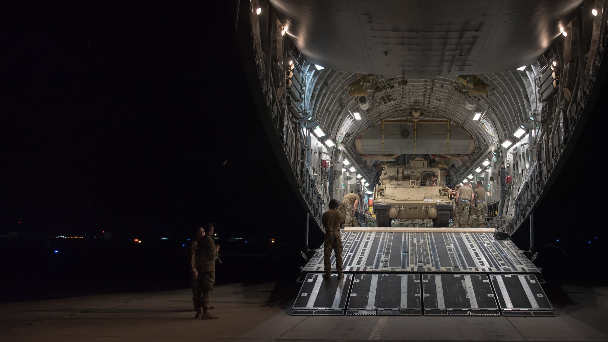 U.S. Airmen assigned to the 386th Expeditionary Logistics Readiness Squadron help guide a U.S. Army Soldier loading a U.S. Army M2 Bradley Fighting Vehicle onto a U.S. Air Force C-17 Globemaster III at Ali Al Salem Air Base, Kuwait, Oct. 30, 2019. Airmen and Soldiers coordinated efforts to transport the BFV within the U.S. Central Command theater of operations to assist in ongoing efforts within the region. (U.S. Air Force photo by Tech. Sgt. Daniel Martinez)