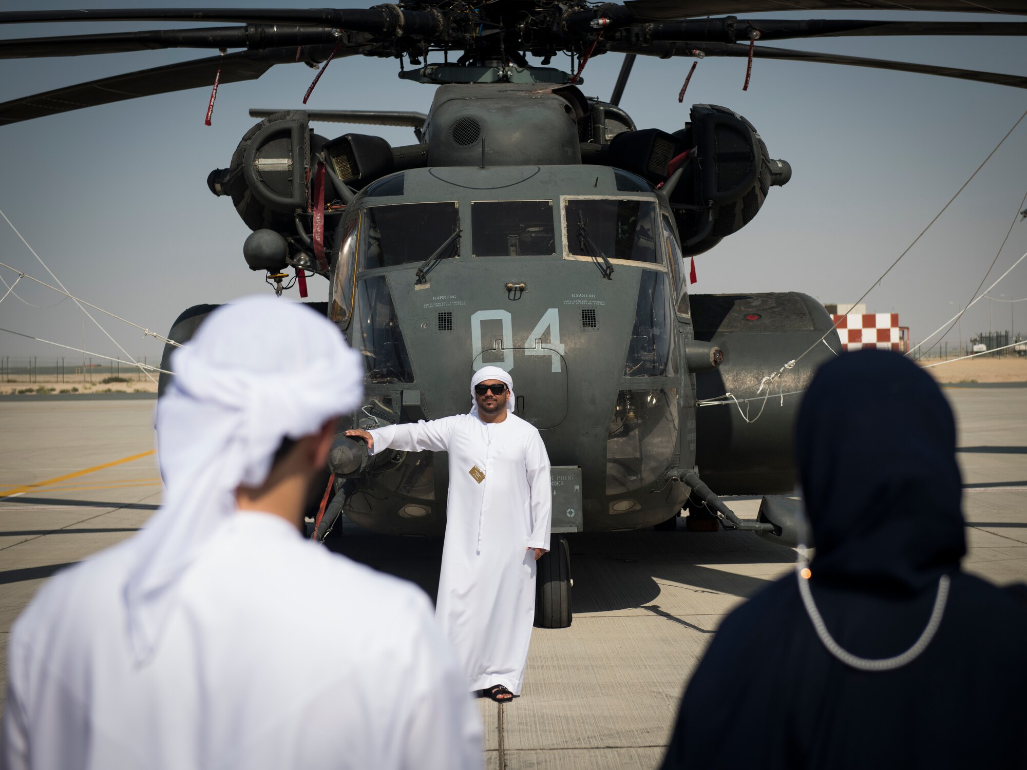 A spectator poses for a photograph with a U.S. Navy MH-53E Sea Dragon at the Dubai Airshow, United Arab Emirates, Nov. 18, 2019.