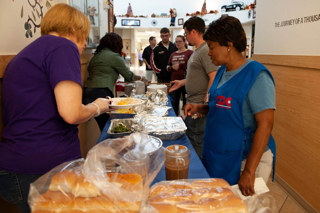 A photo of volunteers serving food during a Thanksgiving meal.