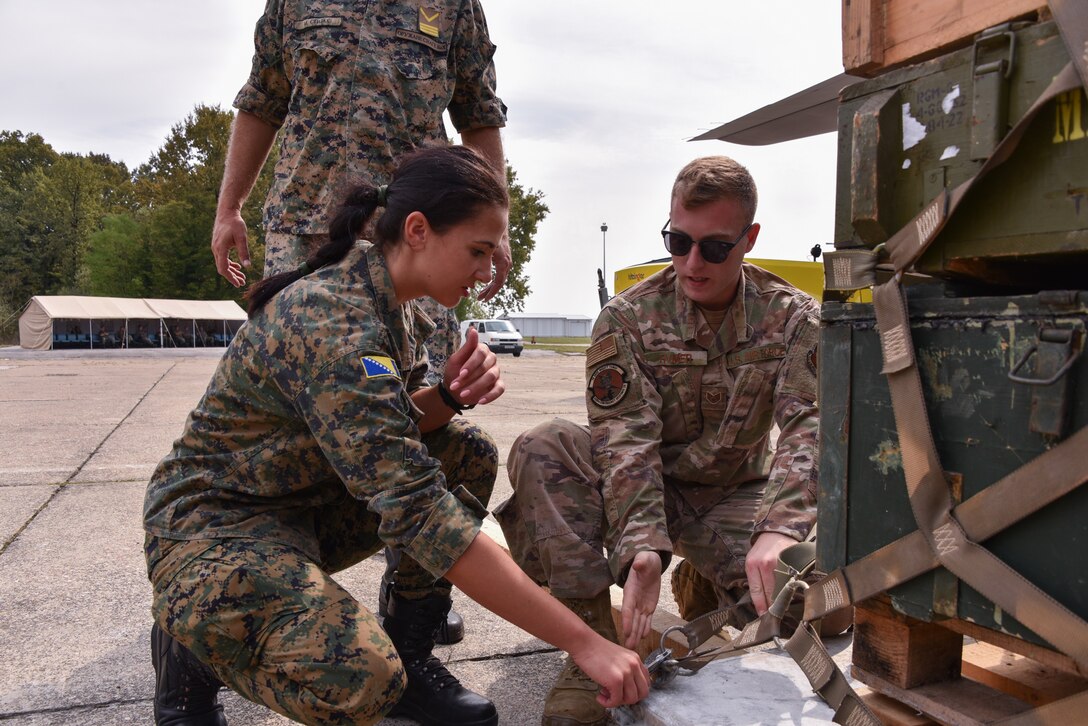 A male and a female service members talk during a training exercise.