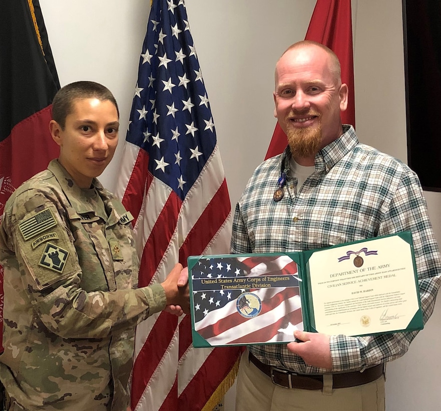David Hardin receives an on the spot award from Kabul Cluster Officer in Charge, MAJ Maria Carver as she presents him with the Secretary of the Army Civilian Service Achievement Medal.