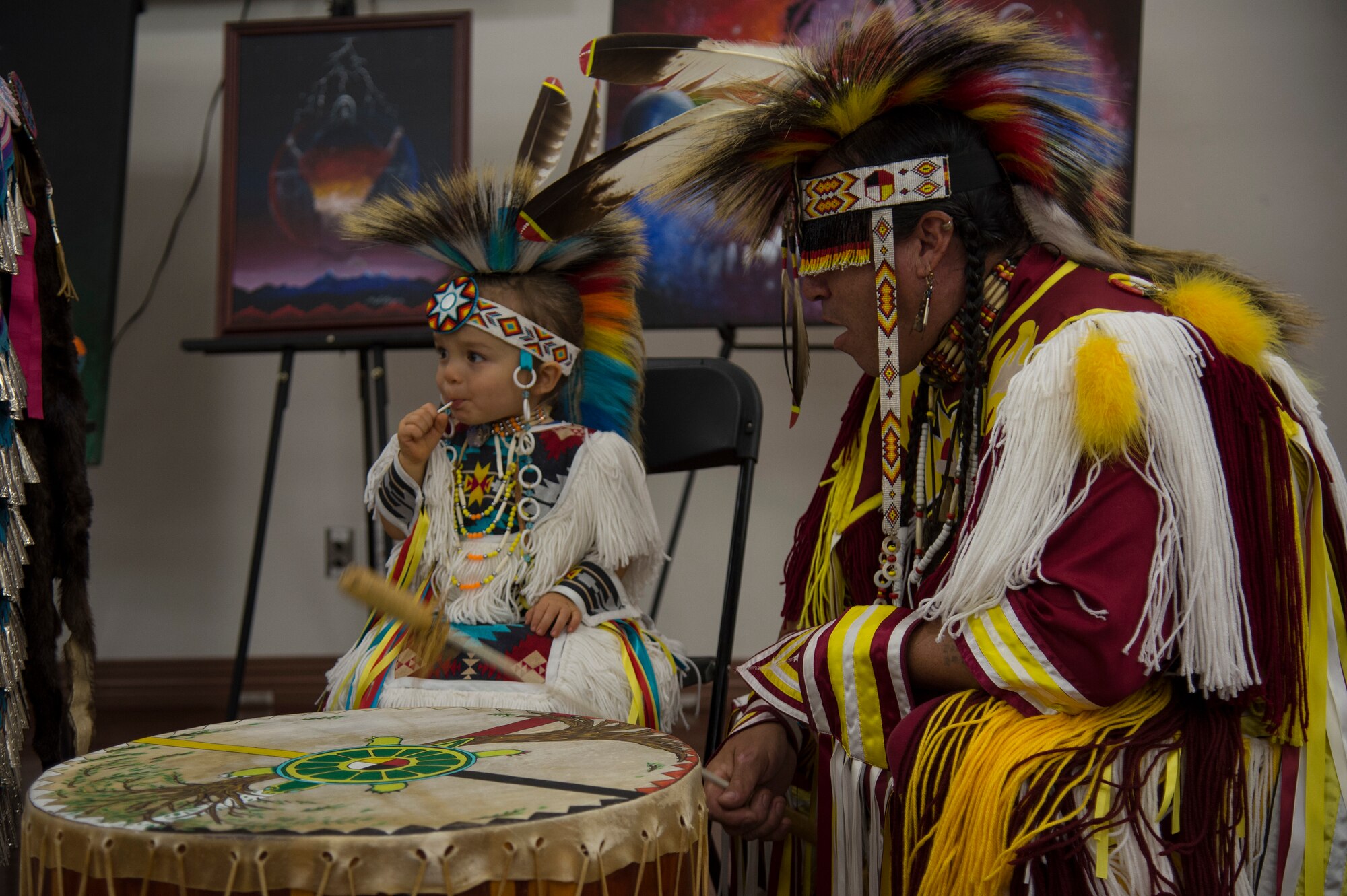 Brian “Blue Jay” Littlejohn, of the Cherokee nation, plays a drum with his grandson Kyler during a Native American Heritage Month Celebration, Nov. 21, 2019, at MacDill Air Force Base, Fla.  Littlejohn performed traditional Cherokee dances during the celebration.