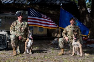 Staff Sgt. Timothy Merrigan, a military working dog handler assigned to the 628th Security Forces Squadron, his K-9 Tze, Staff Sgt. Jenings Casey, 628th SFS MWD training supervisor and his K-9 Elmo, pose after Tze and Elmo's retirement ceremony, Nov. 22, 2019 at Joint Base Charleston, S.C. Elmo served honorably for 10 years before retiring due to age and back problems while Tze's career was cut short at seven years due to back problems of his own. Both K-9s now live with their former handlers after serving their country honorably.