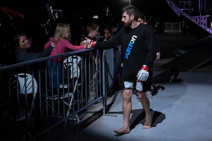 Nelson Tuckwiller, Cage Fury Fighting Championship fighter, interacts with a fan before his fight during the CFFC 80 at Joint Base Langley-Eustis, Virginia, Nov. 22, 2019.