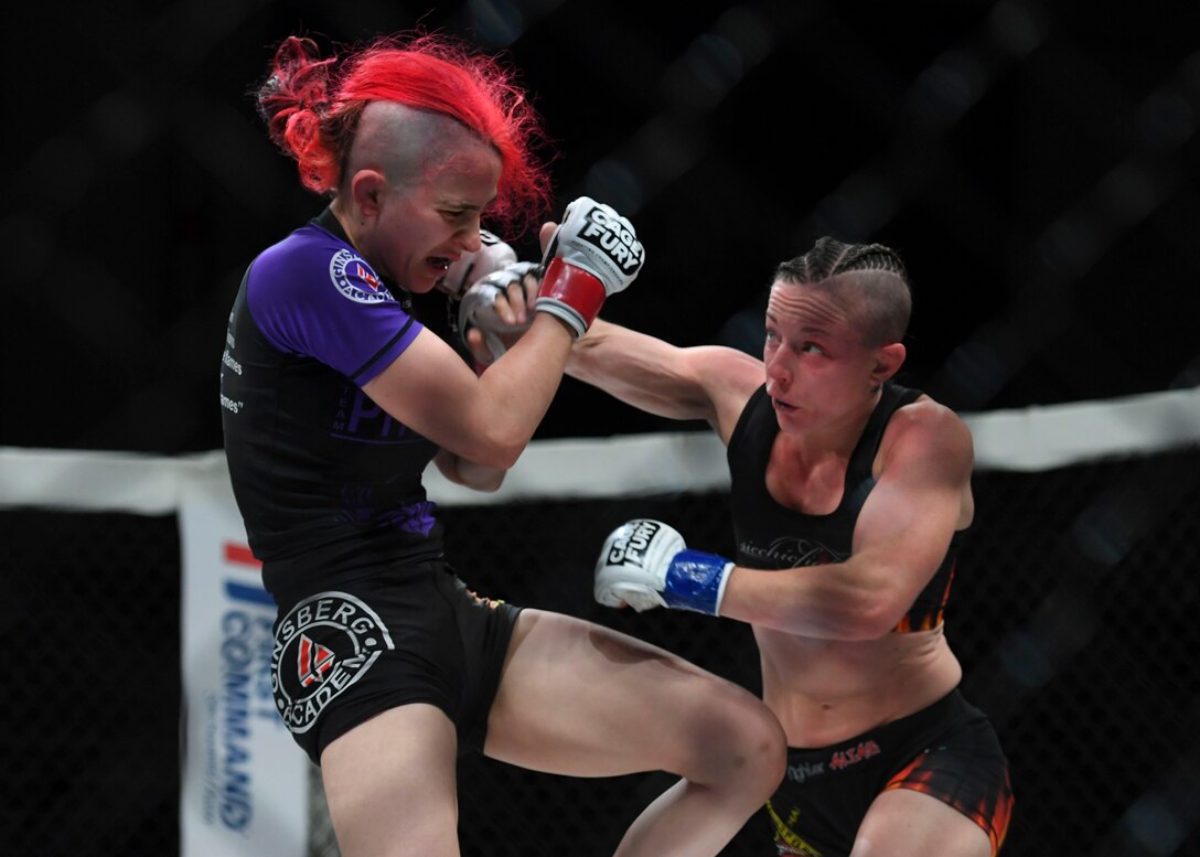 Jillian DeCoursey punches Katie Perez during the Cage Fury Fighting Champion 80 “Fight for Troops” event at Joint Base Langley-Eustis, Virginia, Nov. 22, 2019.
