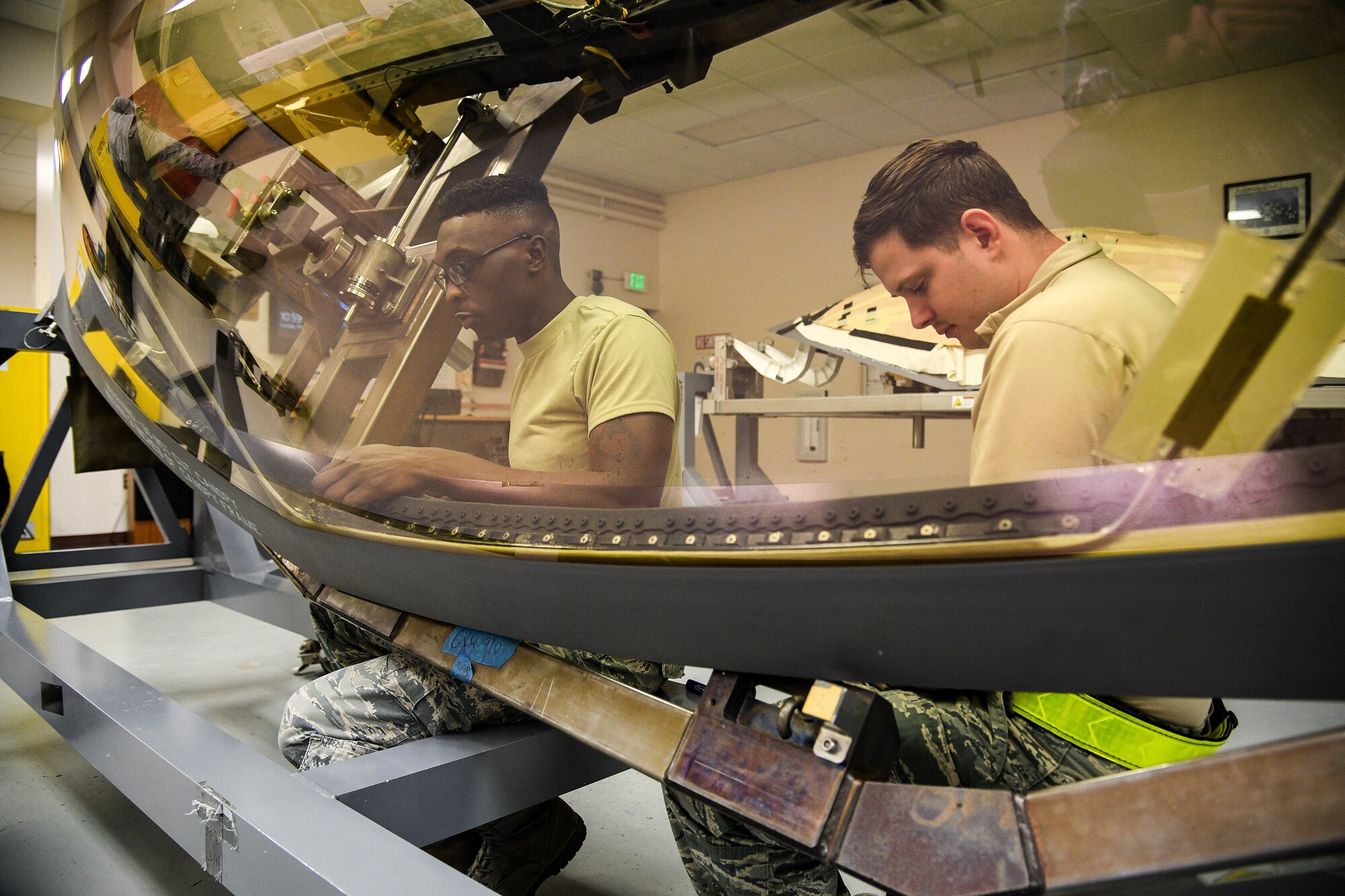 A photo of Airmen working on an F-35A canopy.