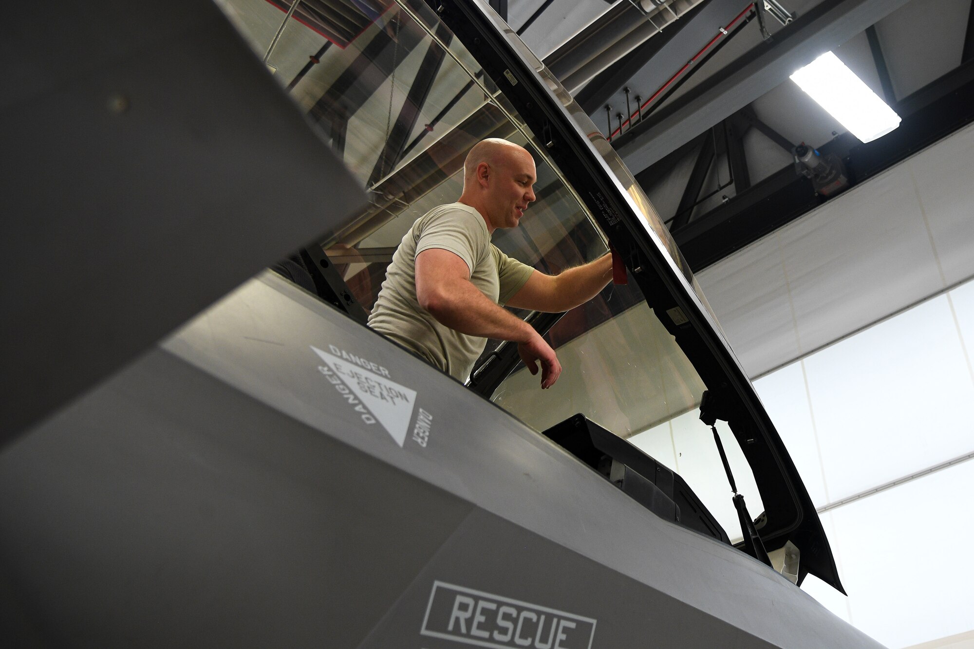 An Airman works on an F-35A canopy.