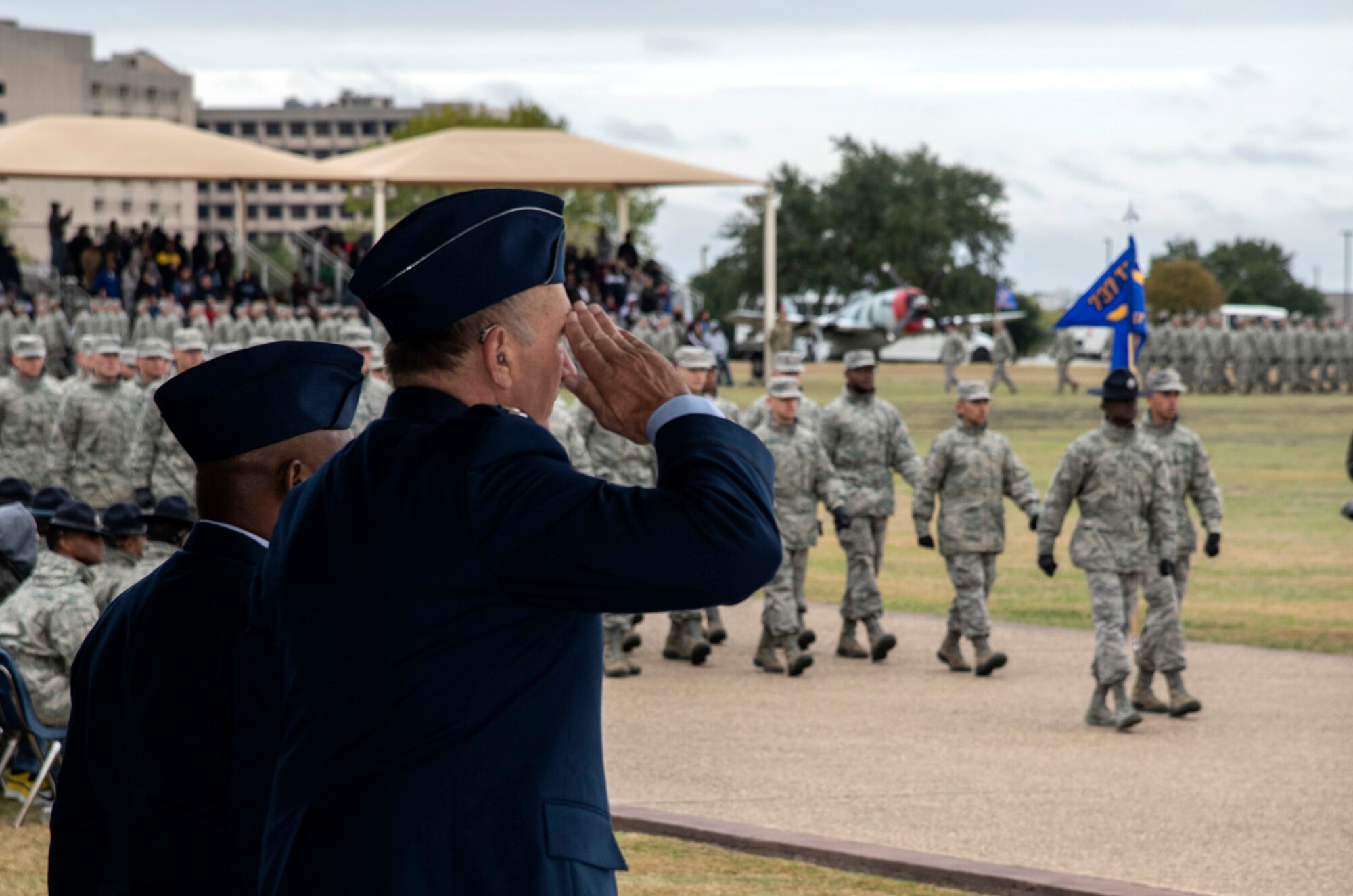 Retired Capt. Guy Gruters, a former F-100 Super Sabre pilot and prisoner of war, serves as the reviewing official during a U.S. Air Force basic military graduation Nov. 8, 2019, at Joint Base San Antonio-Lackland, Texas.  Gruters was an F-100 pilot for more than 20 years and spent more than five of those years as POW in a Vietnam internment camp. His decorations include more than thirty combat awards, including two Silver Stars, two Distinguished Flying Crosses, two Purple Hearts, a Bronze Star Medal for Valor, the POW Medal, a Presidential Unit Citation and 20 Air Medals.