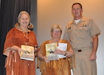 IMAGE: DAHLGREN, Va. (Nov. 21, 2019) - Capt. Casey Plew, Naval Surface Warfare Center Dahlgren Division (NSWCDD) commanding officer, presents the Dahlgren history book, "The Sound of Freedom," to Twila Bradley and Minnie Lightner, guest speakers at the NSWCDD sponsored National American Indian Heritage Month Observance at the base theater. Bradley and Lightner – members of the Patawomeck Indian Tribe of Virginia – spoke about the culture, history, and contributions of the Patawomeck Tribe in terms of the heritage month’s 2019 theme: “Honoring Our Nations: Building Strength Through Understanding”.  (U.S. Navy photo/Released)