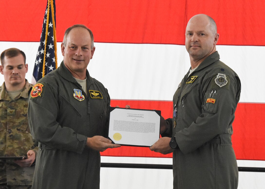 Retired Brig. Gen. Jim Mackey presents the Distinguished Flying Cross with Valor citation to Lt. Col. Anthony Roe, a flight commander with the 303d Fighter Squadron, during a ceremony at Whiteman Air Force Base, Mo., Nov. 2, 2019. Mackey and Roe deployed to Afghanistan in 2008 and flew the mission together that earned Roe his third Distinguished Flying Cross.