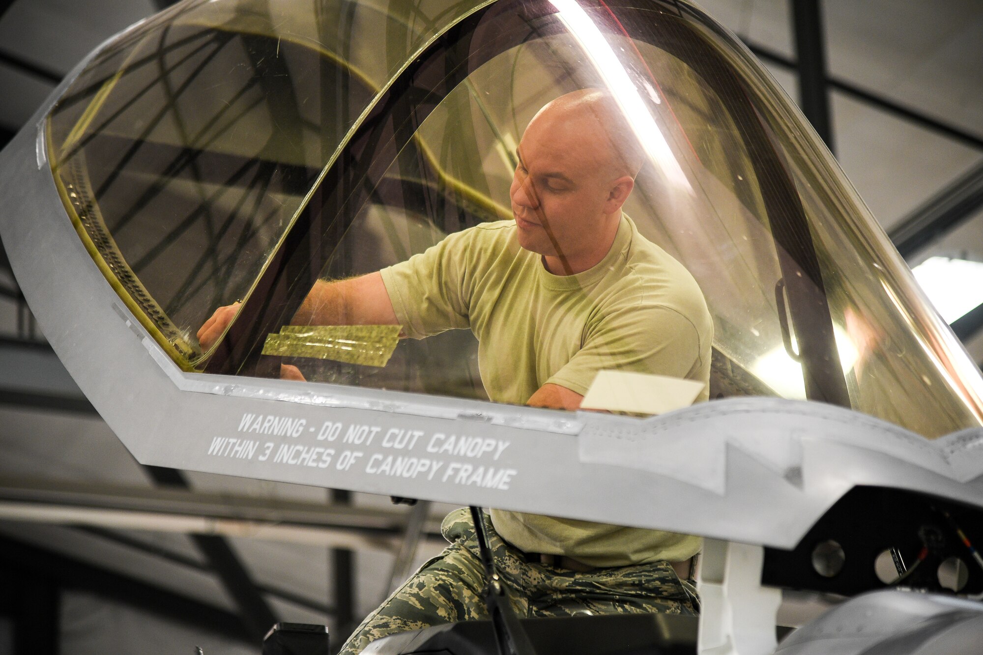 An Airman works on an F-35A canopy.