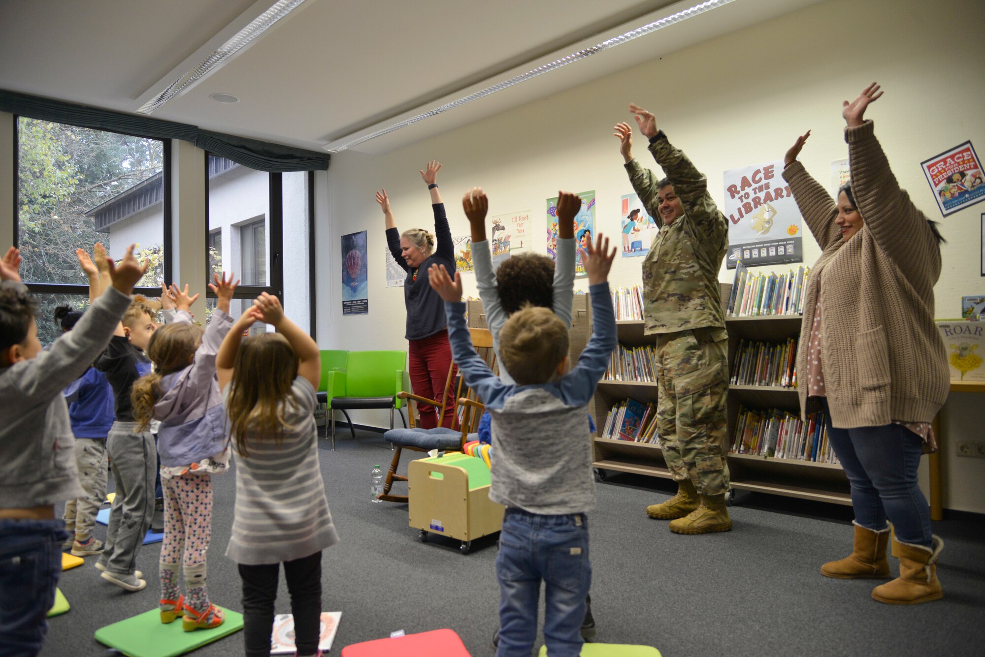 U.S. Air Force Chief Master Sgt. Ernesto J. Rendon, 86th Airlift Wing command chief, and his wife, Melissa, right, participate in the Story Time song at Ramstein Library, Ramstein Air Base, Nov. 21, 2019. Story Time, held Thursdays at 10:30 a.m. at the Ramstein Library and Wednesdays at 10:30 a.m. at the Vogelweh Library, includes songs and crafts, and is geared toward children aged 3 to 5. (U.S. Air Force photo by Airman 1st Class John R. Wright)