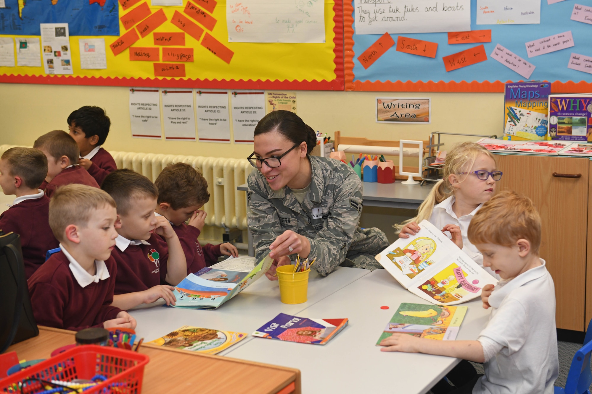 Airman 1st Class Antonia Herrera, 100th Air Refueling Wing Public Affairs broadcast journalist, reads to children at Houldsworth Valley Primary School in Newmarket, England, Nov. 26, 2019. Airmen from Team Mildenhall volunteered their time to go to the school to read books with the children and talk about their jobs on base. (U.S. Air Force photo by Senior Airman Luke Milano)