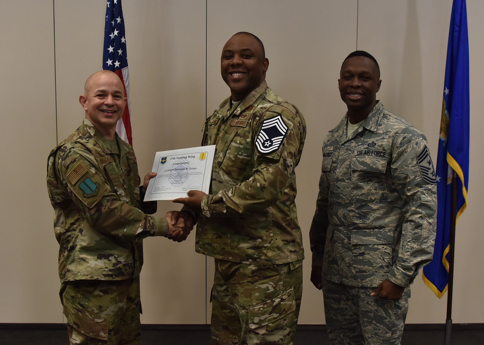 U.S. Air Force Col. Andres Nazario, 17th Training Wing commander, and Chief Master Sgt. Lavor Kirkpatrick, 17th Training Wing command chief, present a promotion certificate to Senior Master Sgt. Charmane Tatum during the Chief Master Sergeant Release Ceremony at the Event Center on Goodfellow Air Force Base, Texas, Nov. 26, 2019. Tatum was one of three 17 TRW members to be selected for promotion to the rank of chief master sergeant. (U.S. Air Force photo by Staff Sgt. Chad Warren/released)