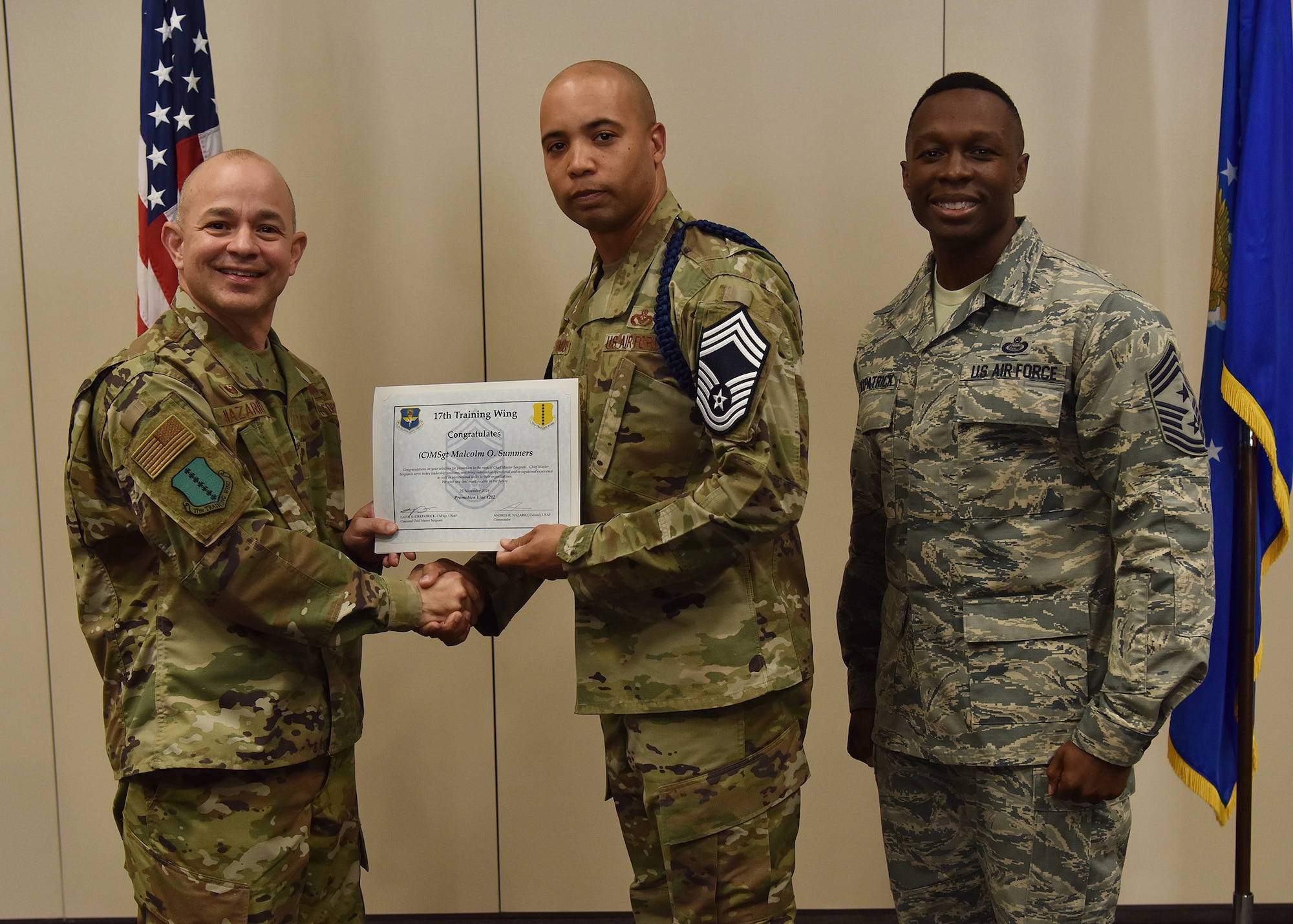 U.S. Air Force Col. Andres Nazario, 17th Training Wing commander, and Chief Master Sgt. Lavor Kirkpatrick, 17th Training Wing command chief, present a promotion certificate to Senior Master Sgt. Malcolm Summers during the Chief Master Sergeant Release Ceremony at the Event Center on Goodfellow Air Force Base, Texas, Nov. 26, 2019. Summers was one of three 17 TRW members to be selected for promotion to the rank of chief master sergeant. (U.S. Air Force photo by Staff Sgt. Chad Warren/released)