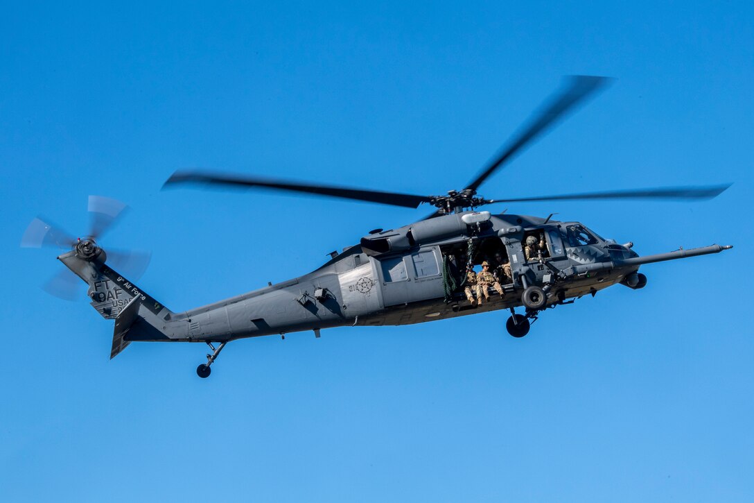 A photo of Airmen flying in a helicopter